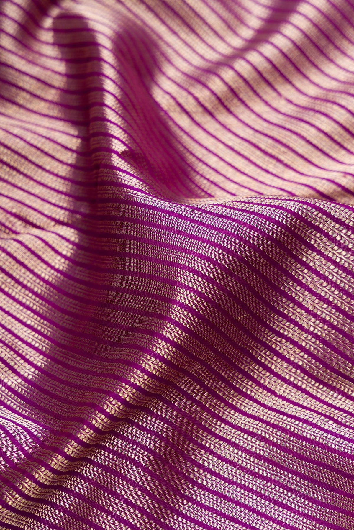 Close up of Purple Dual Tone Kanchipuram Silk Saree with Zari Brocade on the body and Zari Border.  displaying folds
