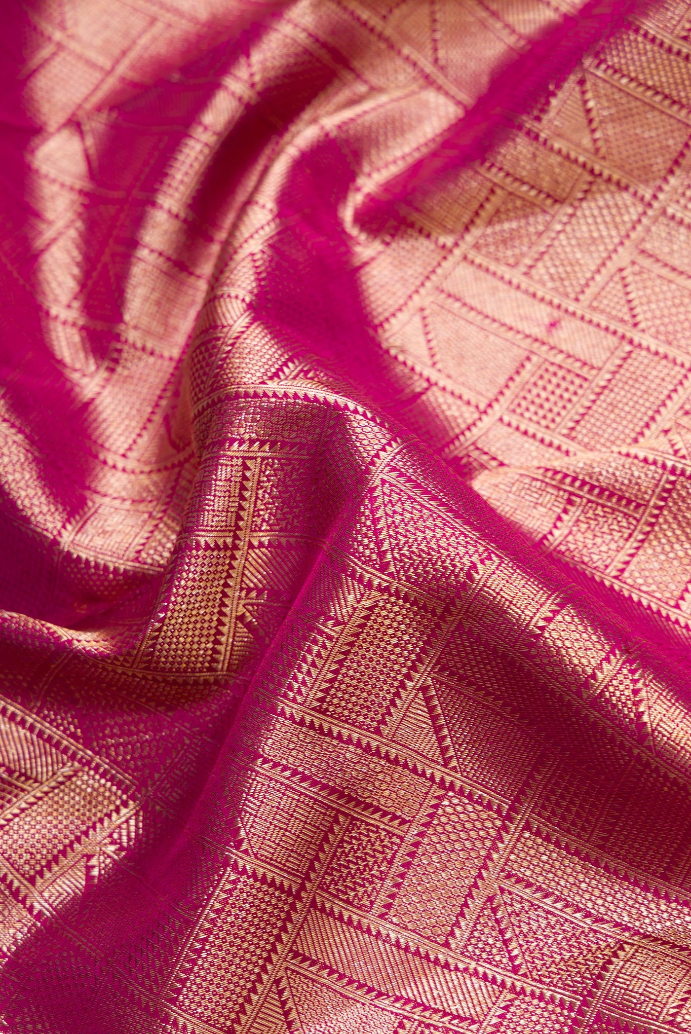 Close up of Magenta Dual Tone Kanchipuram Silk Saree with Zari Brocade on the body and Zari Border.  displaying folds
