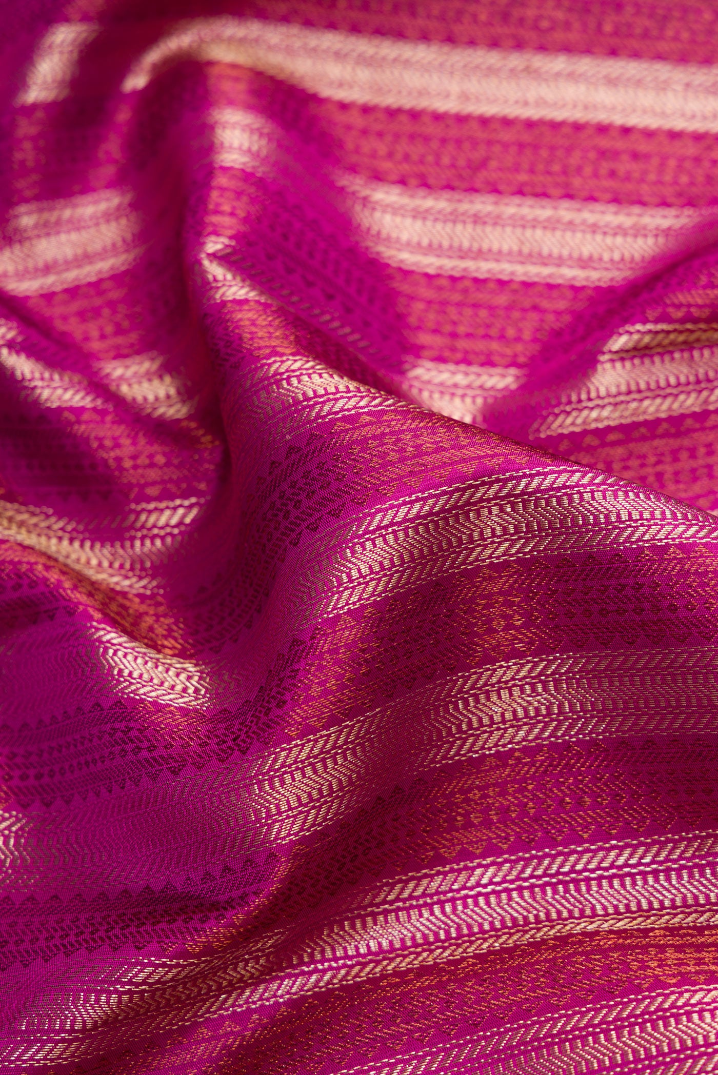 Close up of Magenta Dual Tone Kanjivaram Silk Saree with Zari Brocade on the body and Fancy Border.  displaying folds