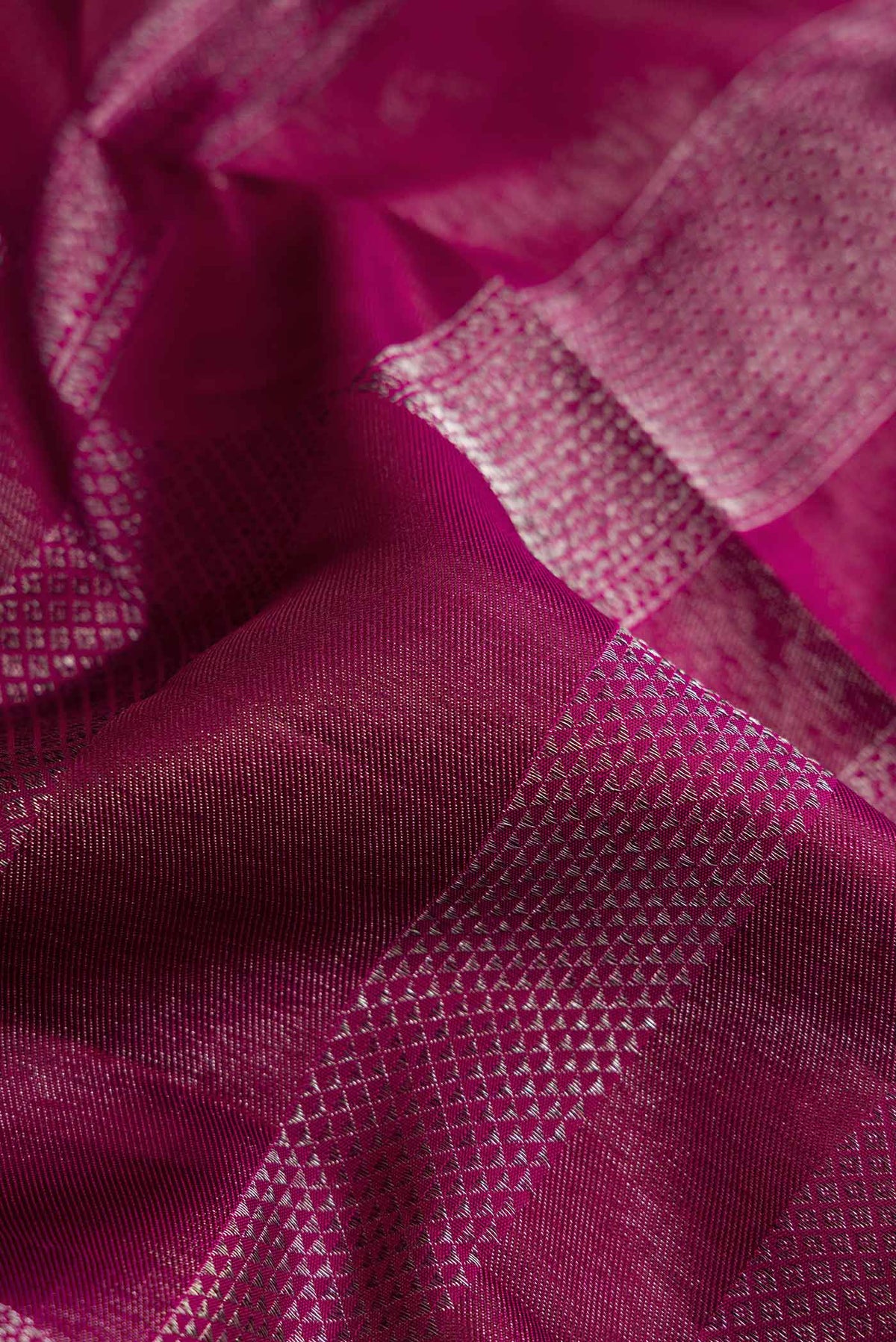 Close up of Magenta Dual Tone Kanchipuram Silk Saree with Zari Brocade on the body and Zari Border displaying folds
