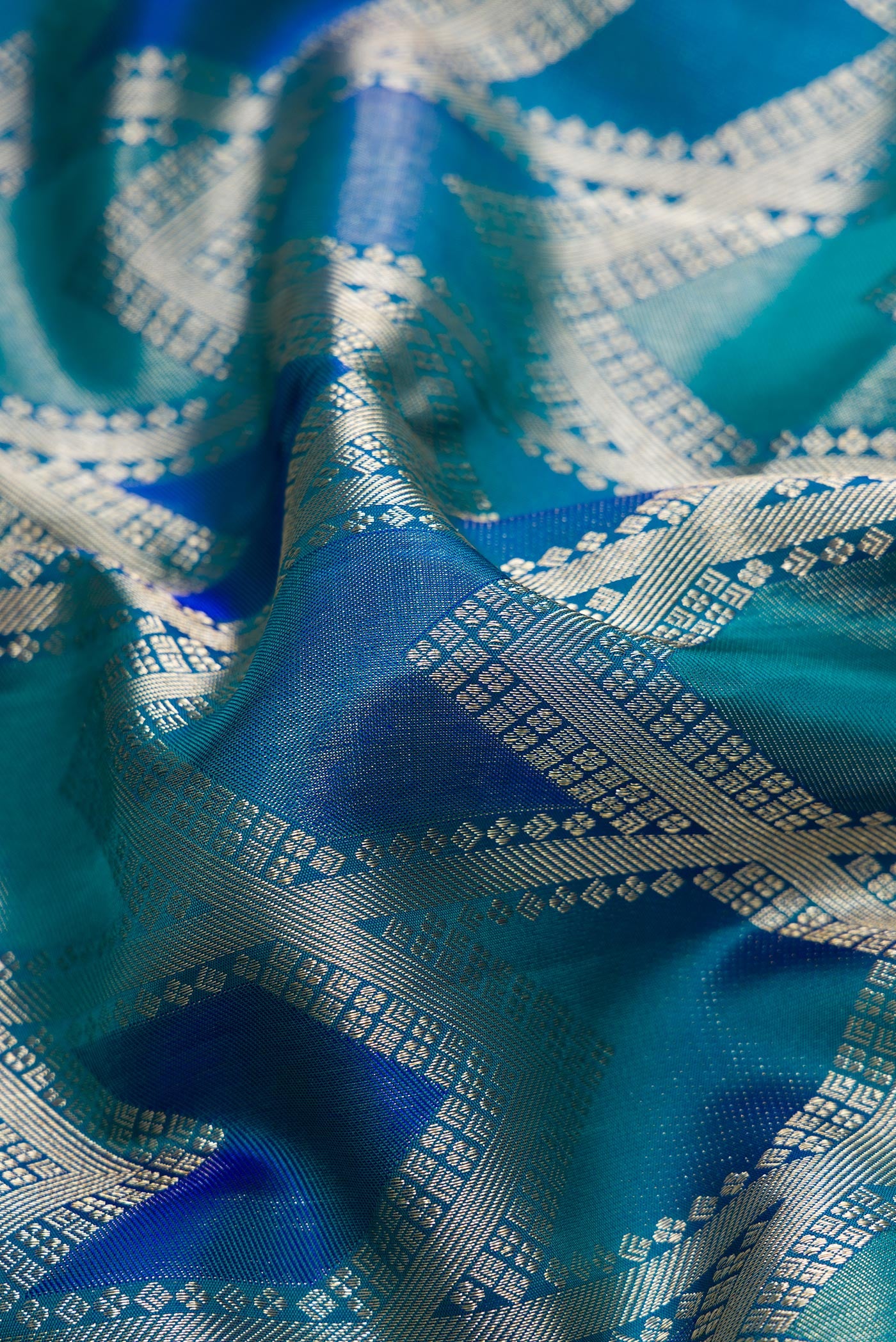 Close up of Peacock Blue Dual Tone Kanjivaram Silk Saree with Zari Brocade on the body and Zari Border.  displaying folds