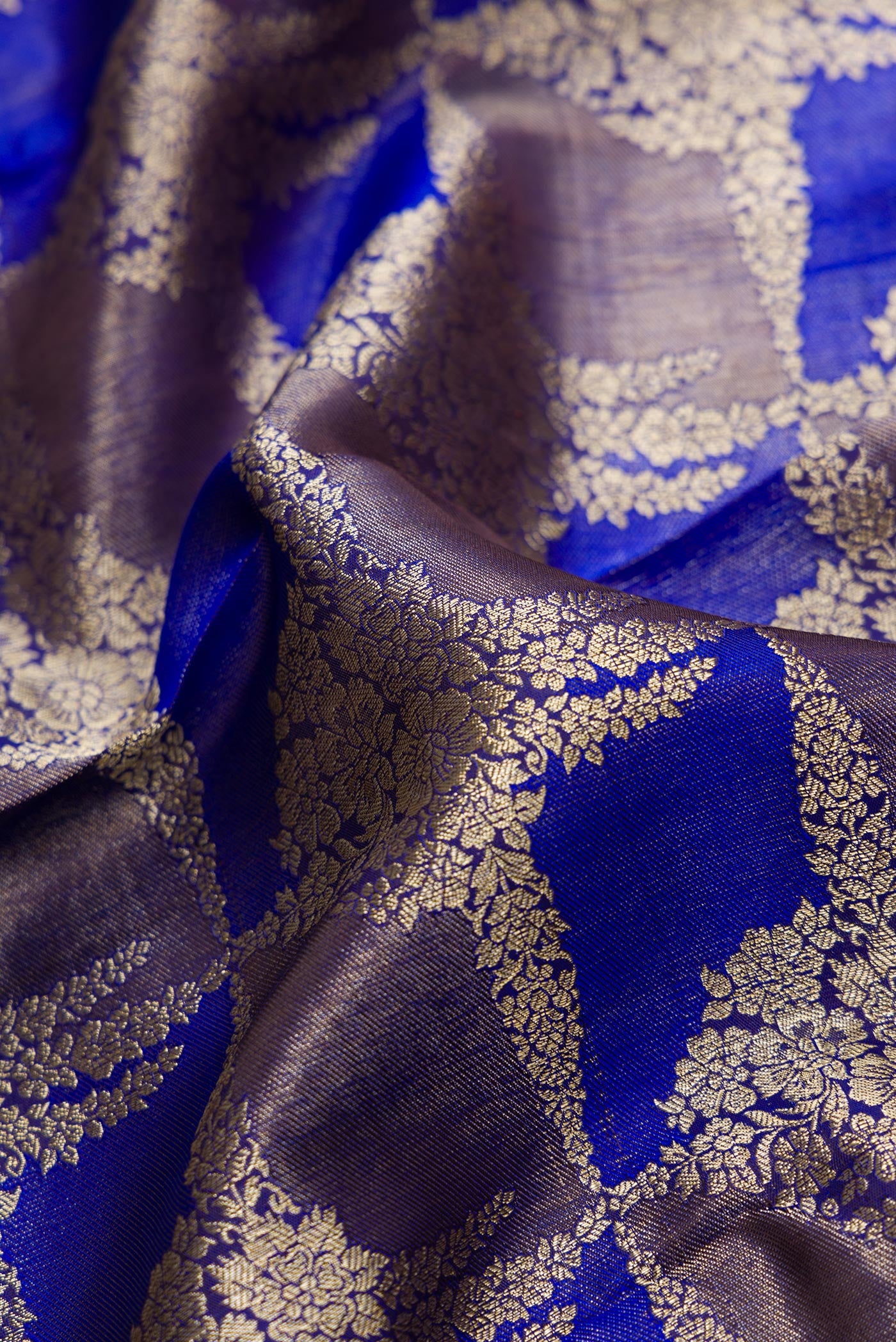 Close up of Violet Dual Tone Kanjivaram Silk Saree with Zari Brocade on the body and Zari Border.  displaying folds