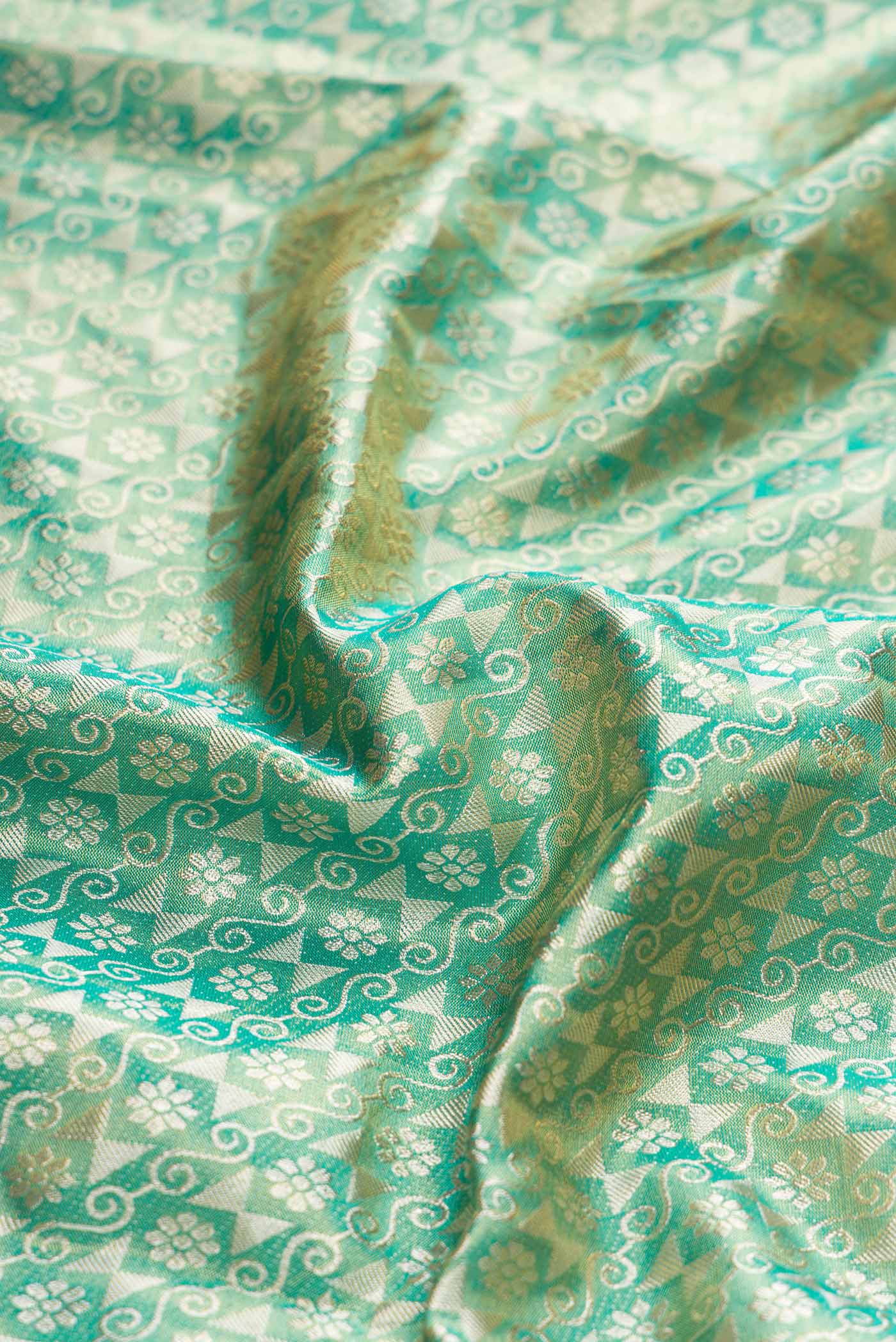 Close up of Green Dual Tone Kanchipuram Tissue Silk Saree with Zari Brocade on the body and Zari Border displaying folds