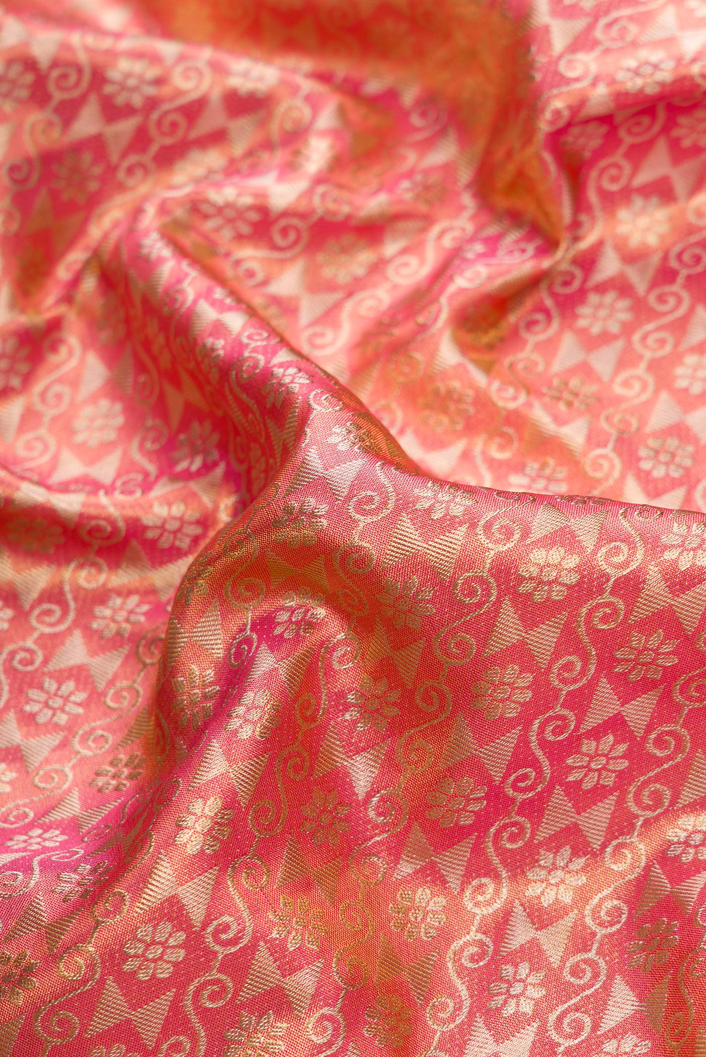 Close up of Golden Peach Dual Tone Kanchipuram Tissue Silk Saree with Zari Brocade on the body and Zari Border.  displaying folds