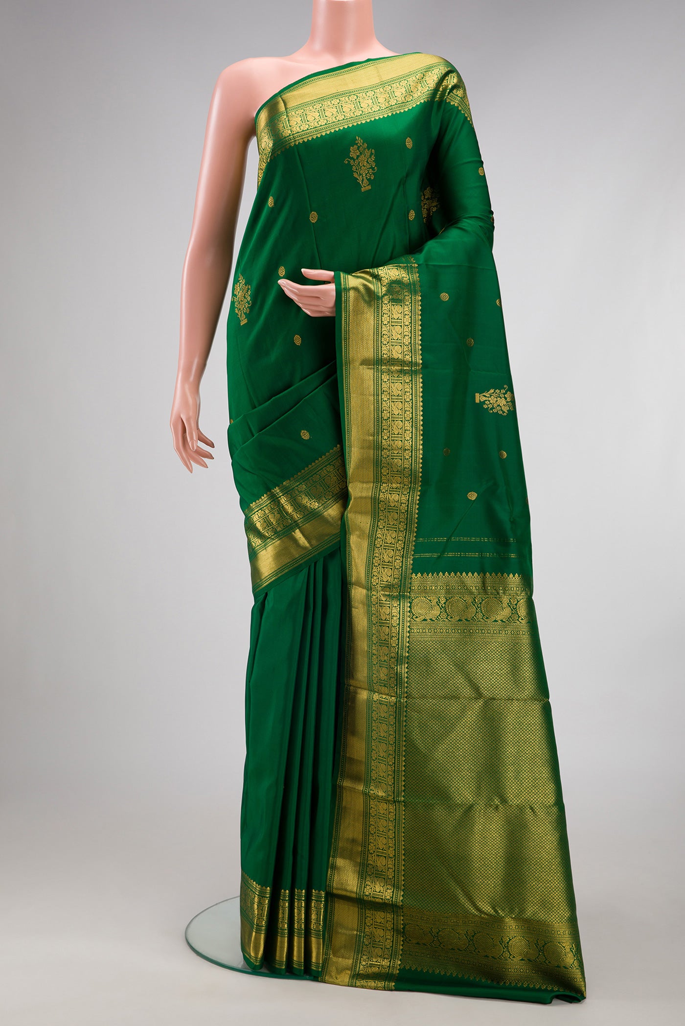Bottle Green Kanchipuram Silk Saree with Zari Butta on the body and Fancy Border.  displayed on a mannequin