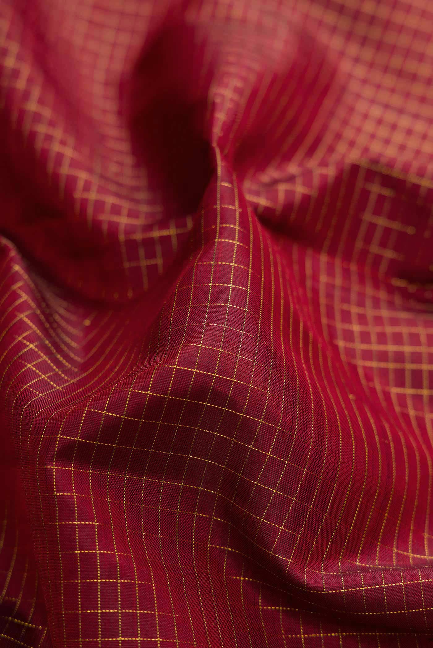 Close up of Maroon Dual Tone Kanjivaram Silk Saree with Checked design on the body and Fancy Border.  displaying folds