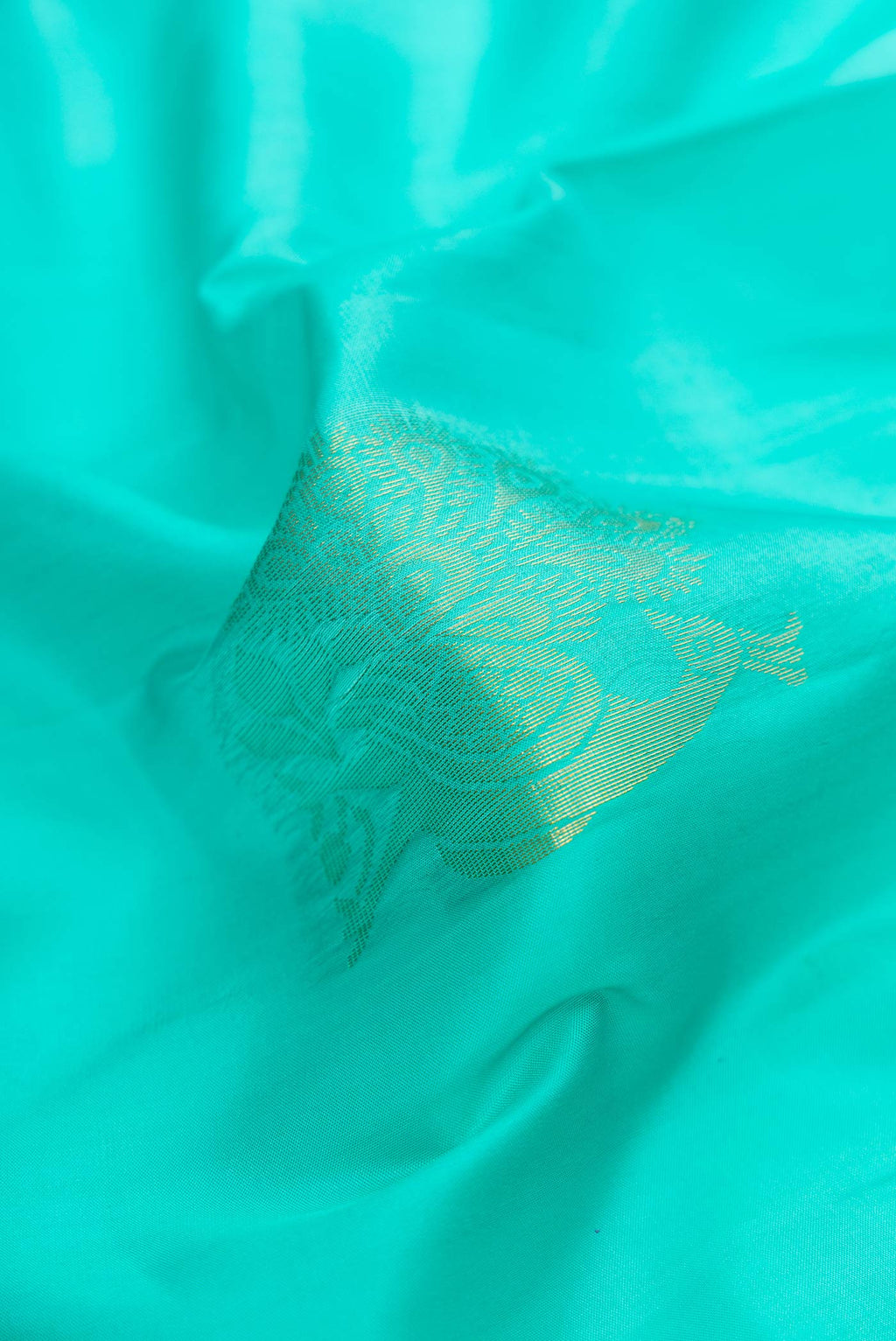 Close up of Sea Green Dual Tone Soft Silk Saree with Zari Butta on the body and Zari Border.  displaying folds