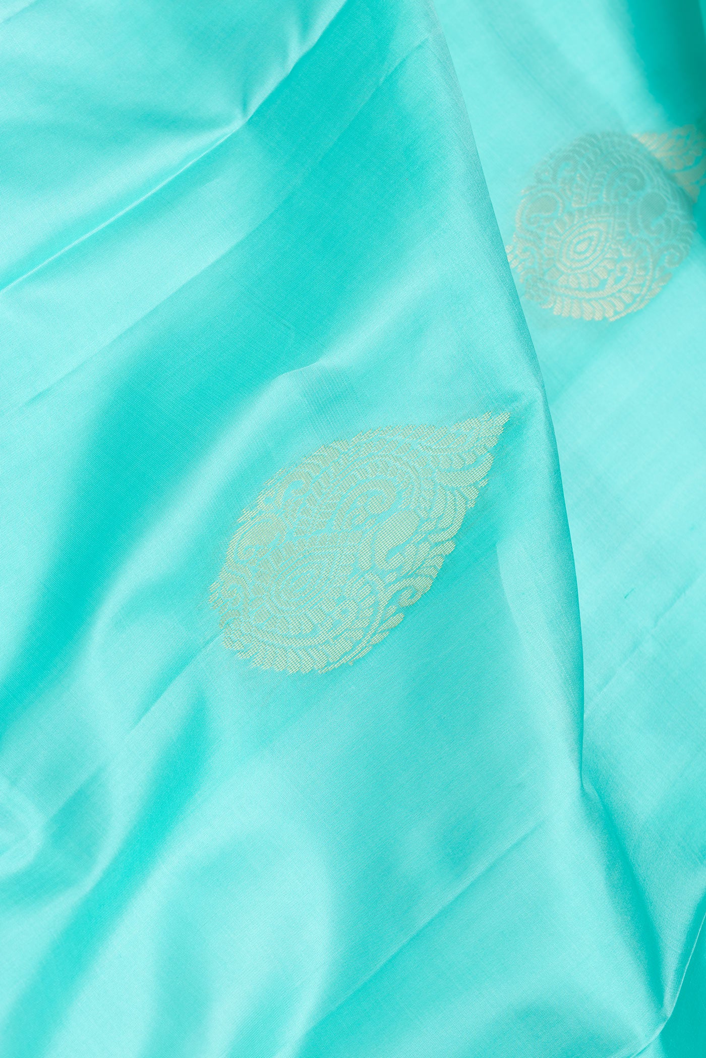 Close up of Sea Green Dual Tone Soft Silk Saree with Zari Butta on the body and Zari Border.  displaying folds