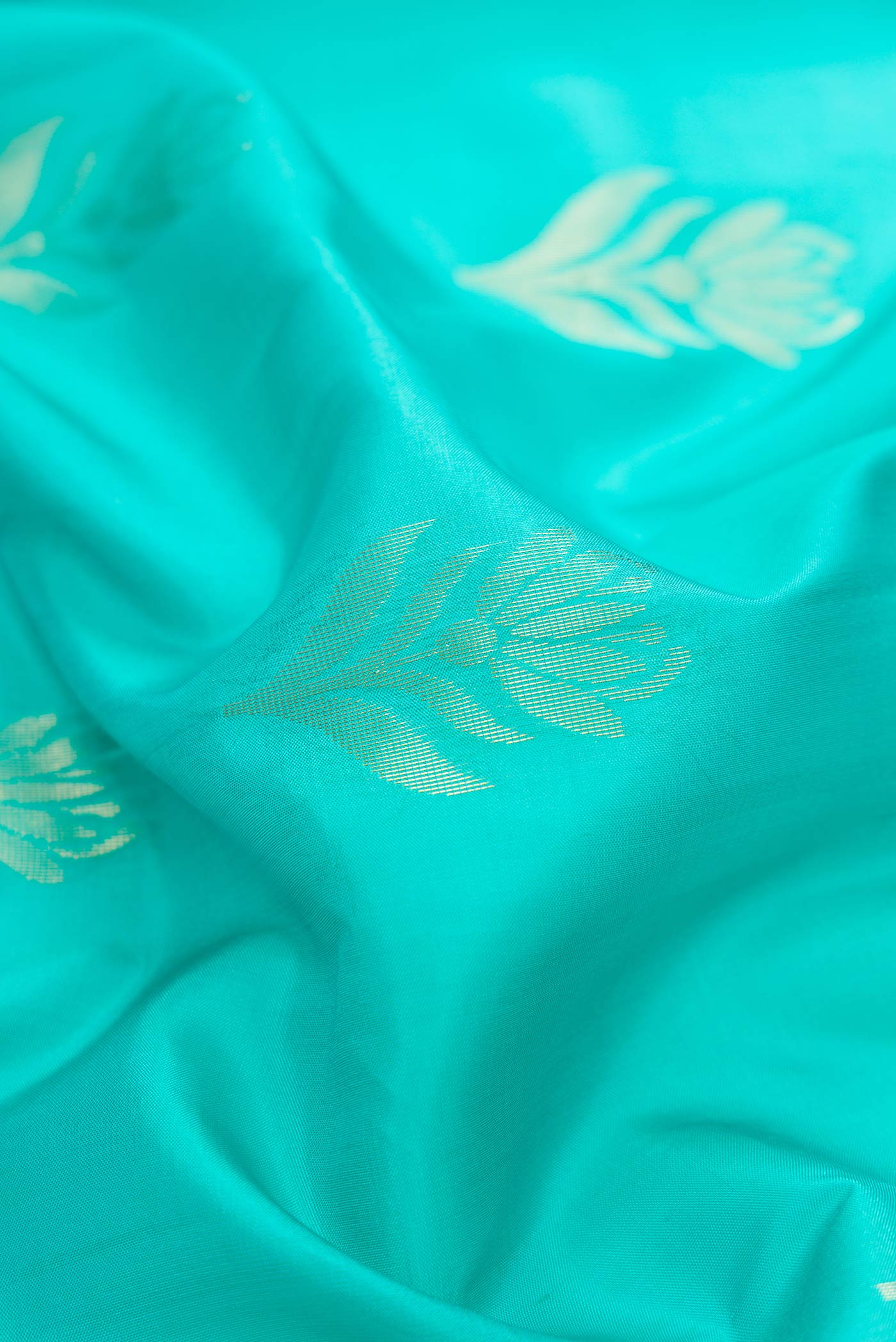 Close up of Sea Green Dual Tone Soft Silk Saree with Zari Butta on the body and Fancy Border.  displaying folds
