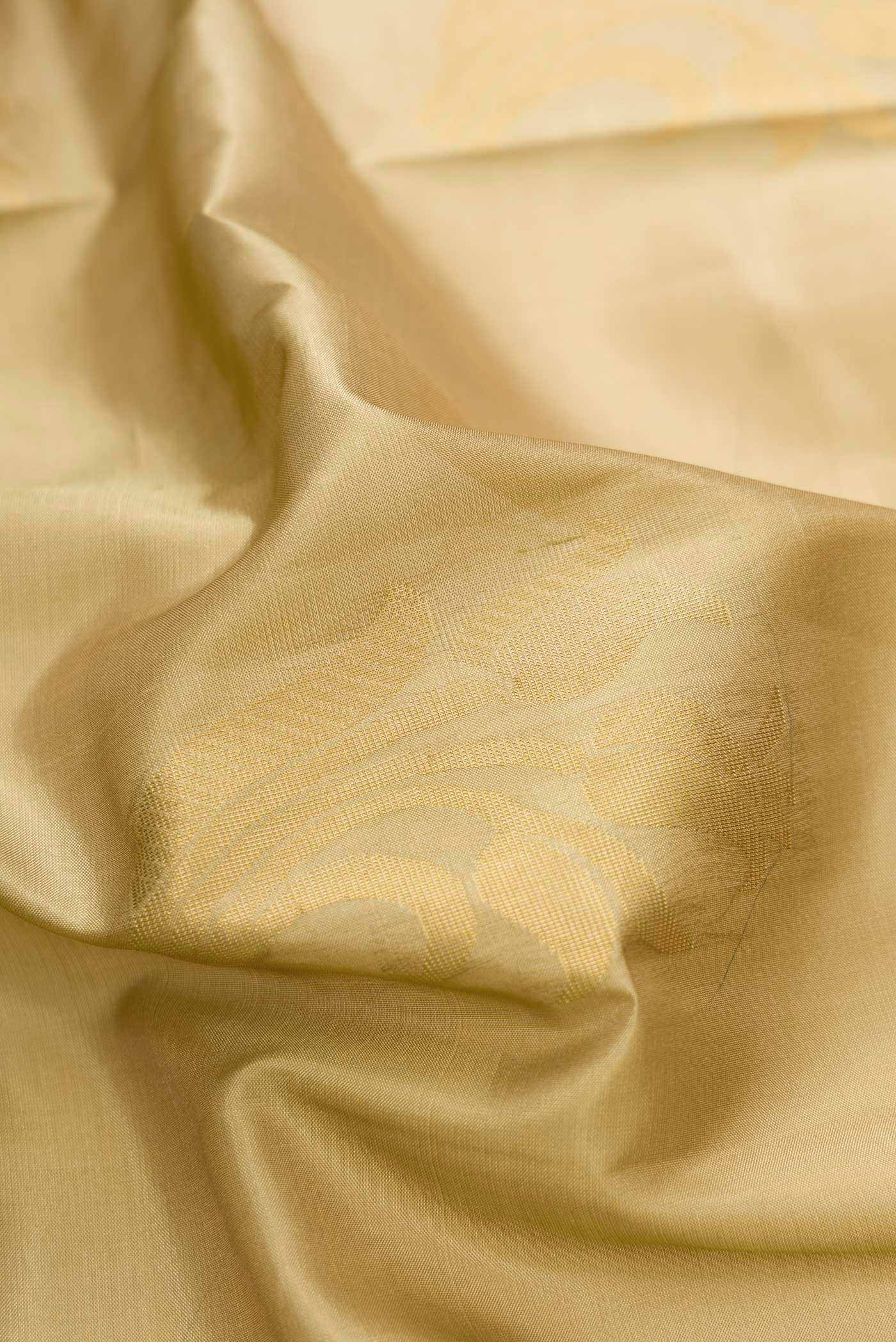 Close up of Gold Dual Tone Soft Silk Saree with Zari Butta on the body and Zari Border.  displaying folds