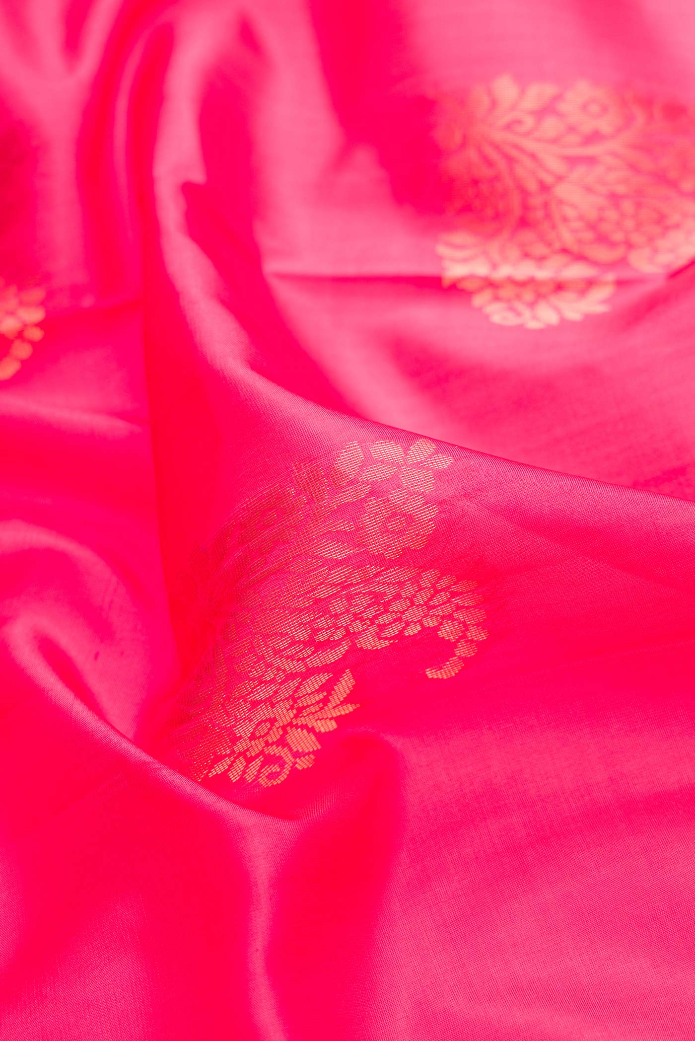 Close up of Pink Dual Tone Soft Silk Saree with Zari Butta on the body and Zari Border.  displaying folds