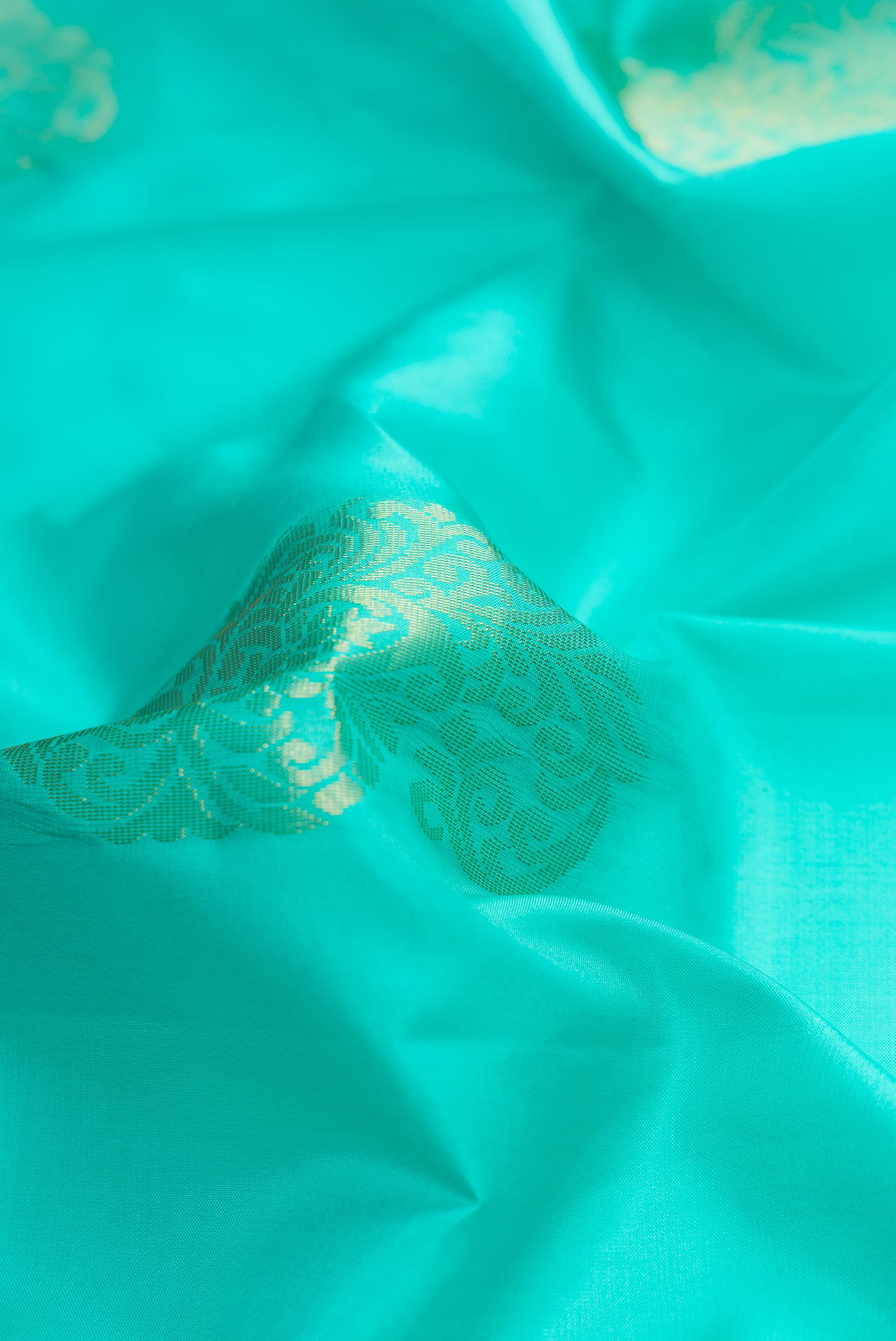 Close up of Sea Green Dual Tone Soft Silk Saree with Zari Butta on the body and Zari Border.  displaying folds