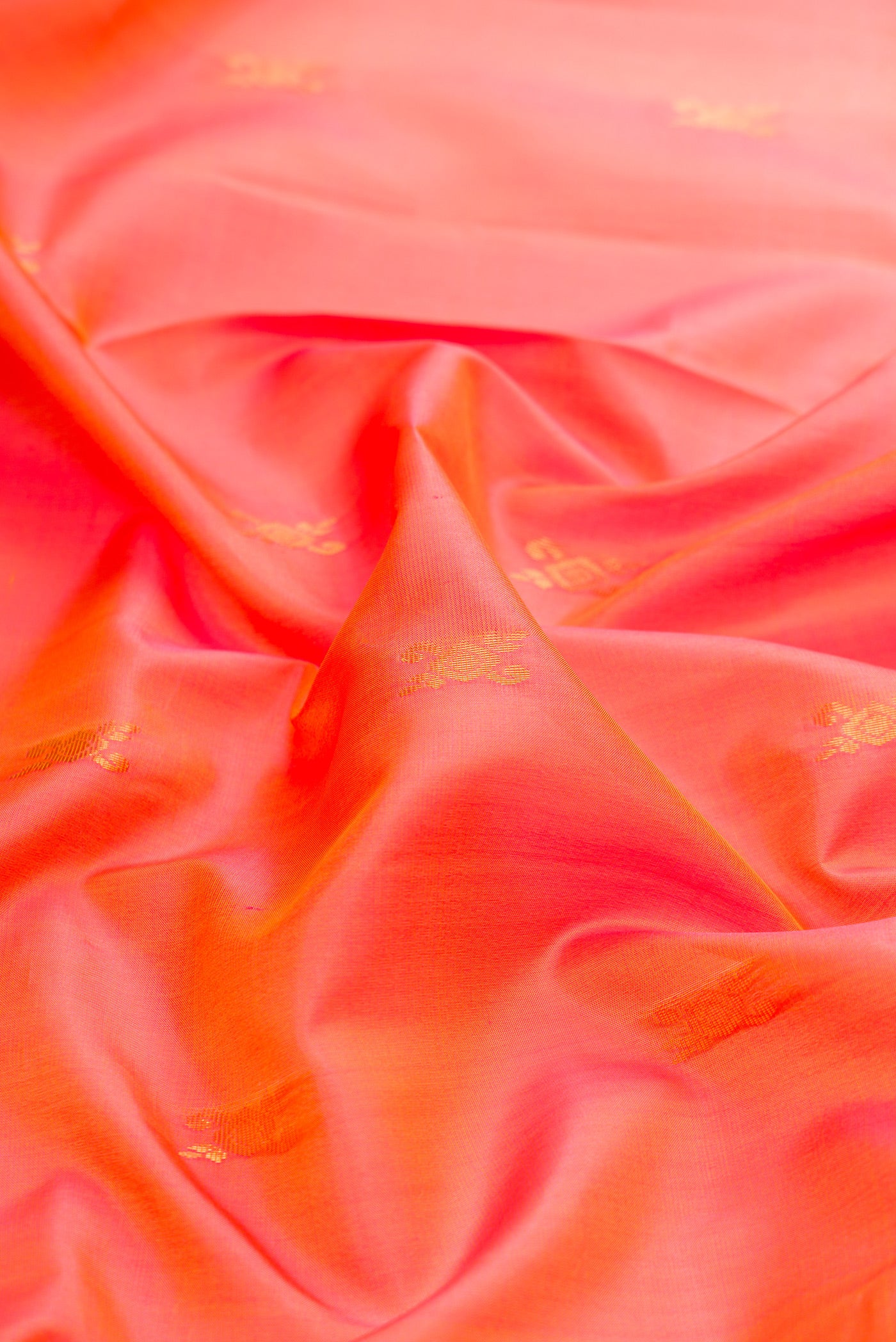 Close up of Coral Dual Tone Soft Silk Saree with Zari Butta on the body and Zari Border.  displaying folds
