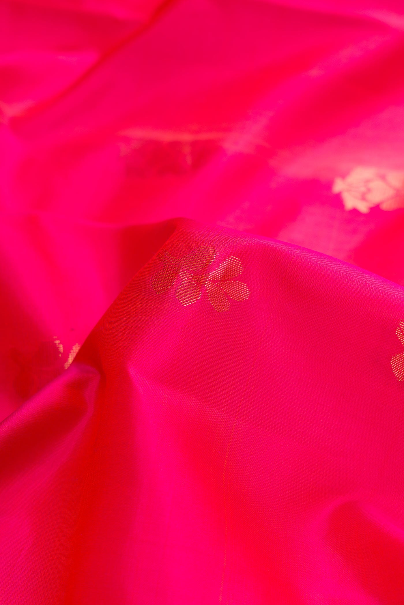 Close up of Orange Dual Tone Soft Silk Saree with Zari Butta on the body and Zari Border.  displaying folds