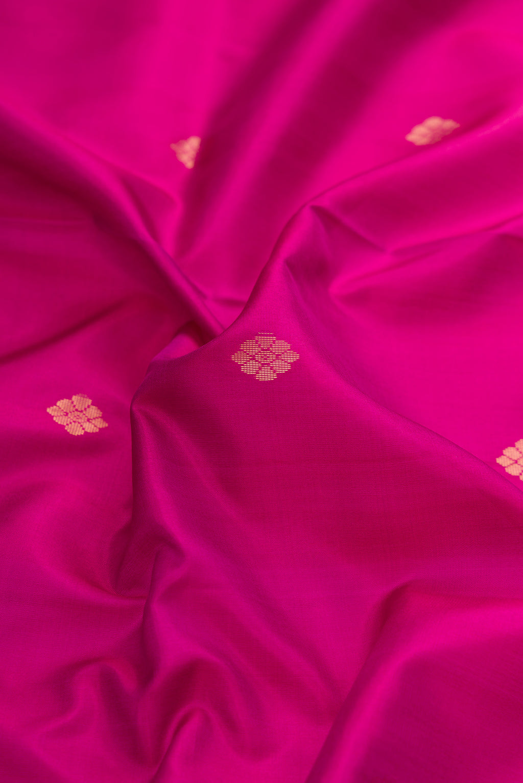 Close up of Magenta Dual Tone Soft Silk Saree with Zari Butta on the body and Fancy Border.  displaying folds