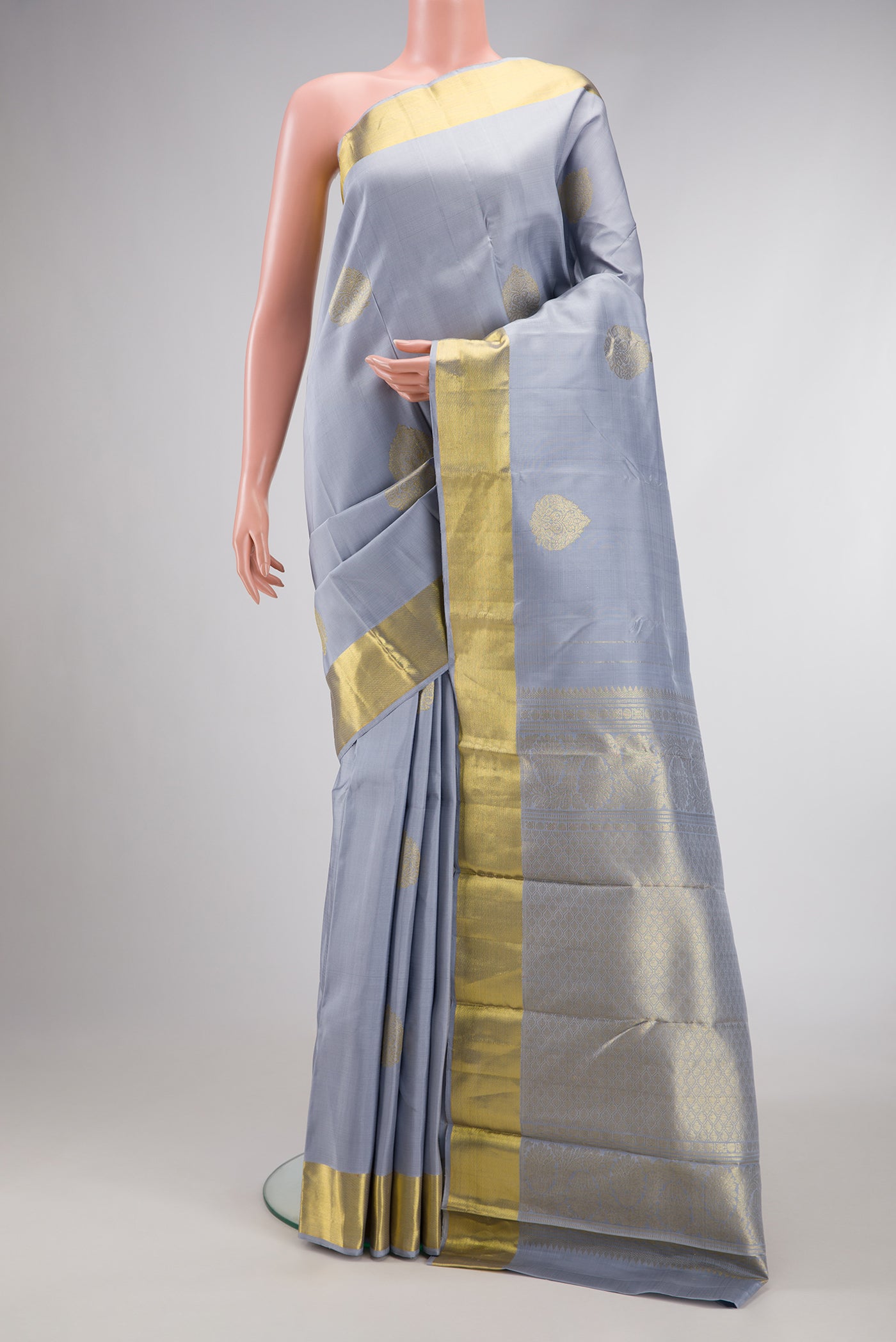 Grey Dual Tone Kanjivaram Silk Saree with Zari Butta on the body and Zari Border.  displayed on a mannequin
