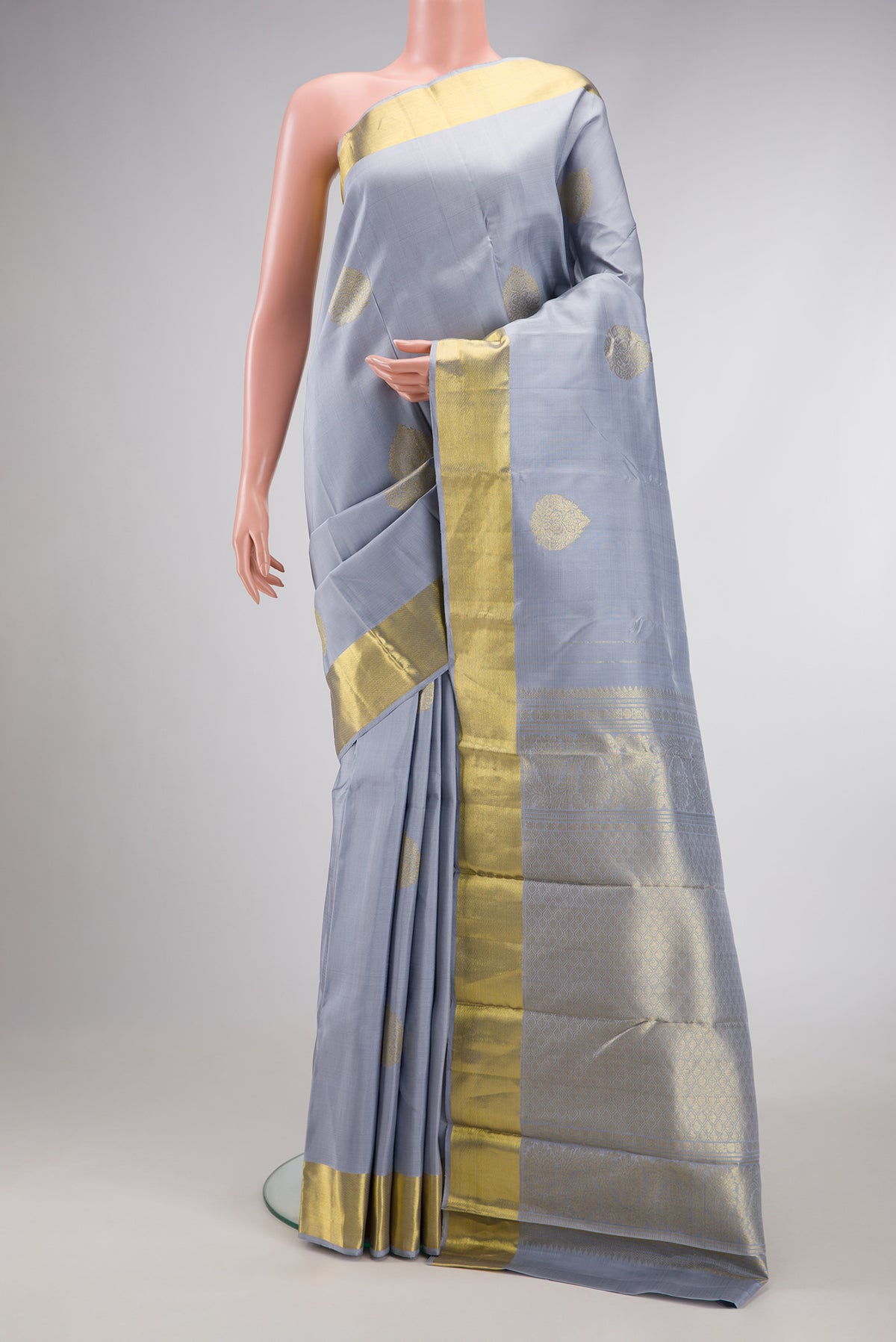 Grey Dual Tone Kanjivaram Silk Saree with Zari Butta on the body and Zari Border.  displayed on a mannequin