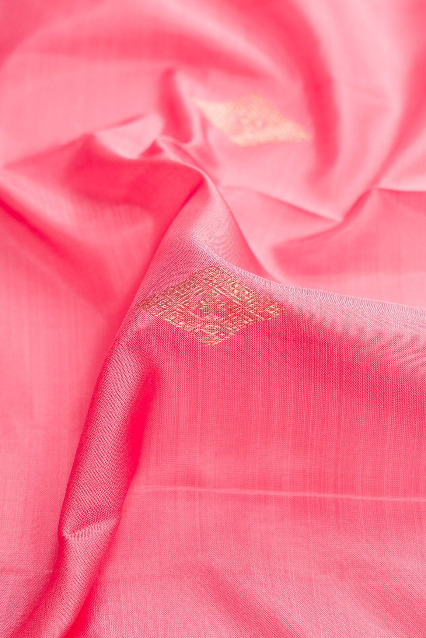 Close up of Pink Dual Tone Kanjivaram Silk Saree with Zari Butta on the body and Zari Border.  displaying folds