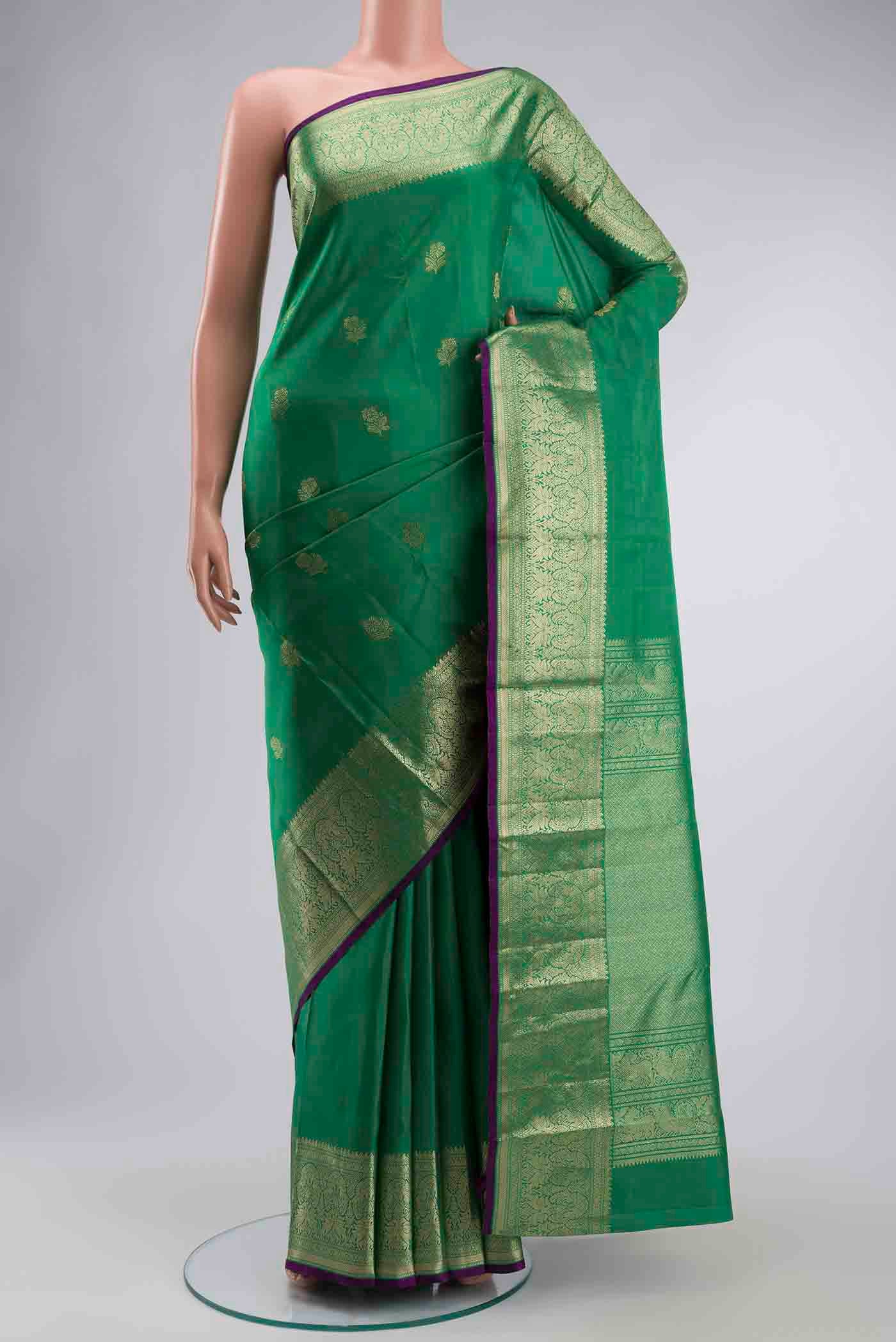 Green Kanchipuram Silk Saree with Zari Butta on the body and Zari Border displayed on a mannequin