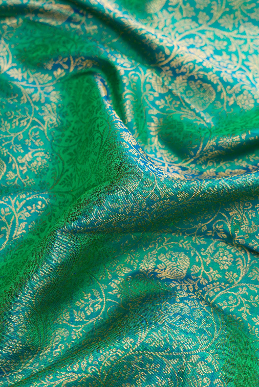 Close up of Green Dual Tone Kanchipuram Silk Saree with Zari Brocade on the body and Zari Border.  displaying folds