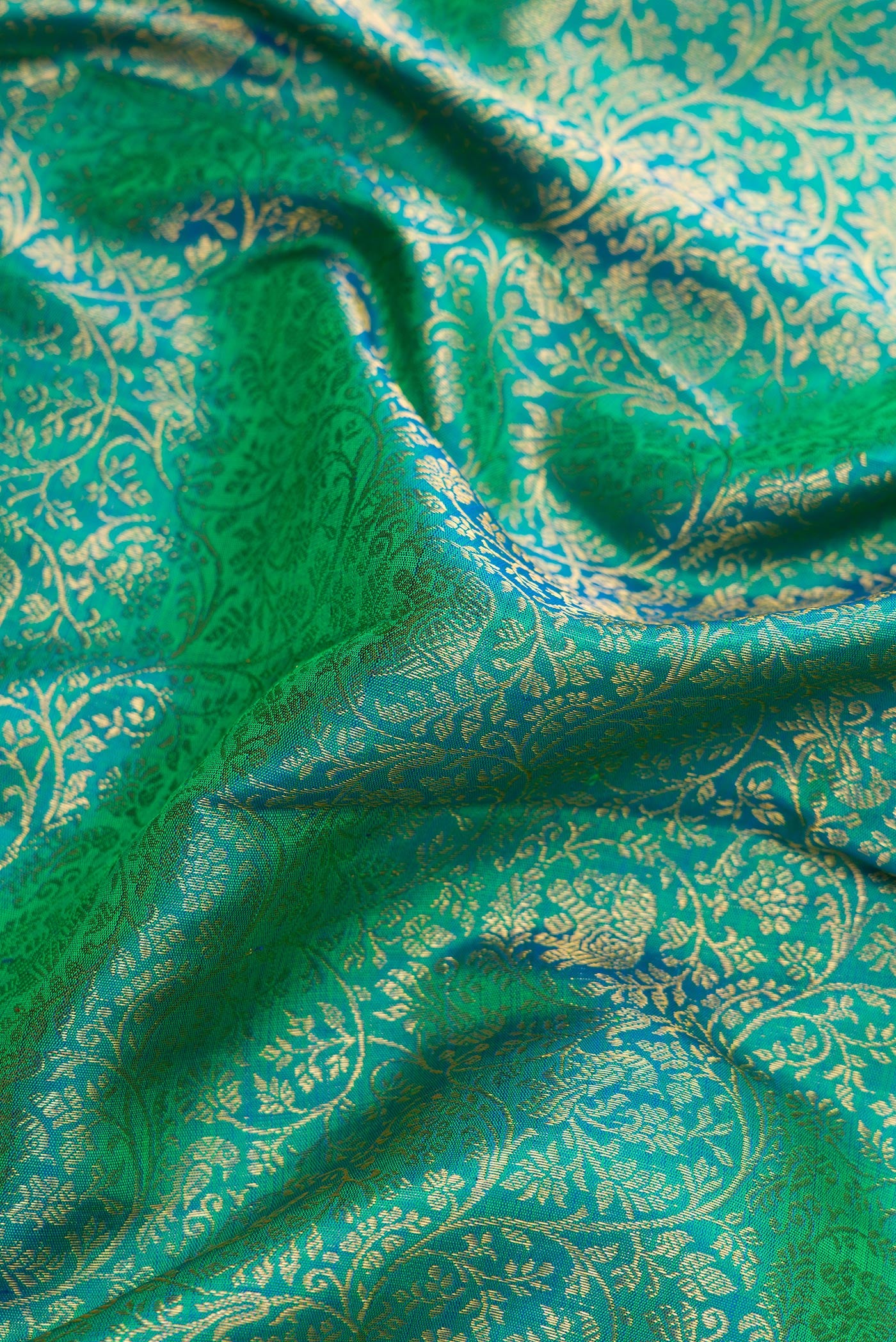 Close up of Green Dual Tone Kanchipuram Silk Saree with Zari Brocade on the body and Zari Border.  displaying folds
