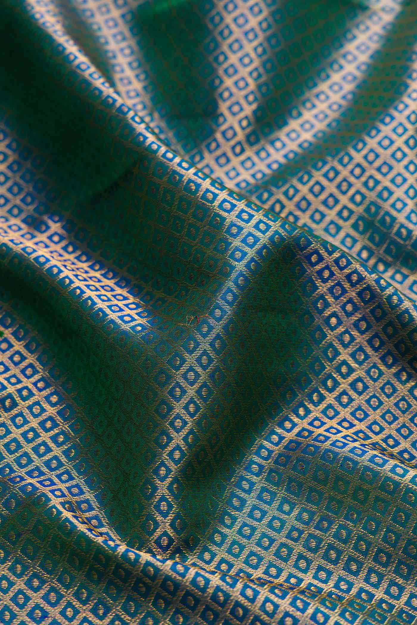 Close up of Peacock Blue Dual Tone Kanchipuram Silk Saree with Zari Brocade on the body and Zari Border displaying folds