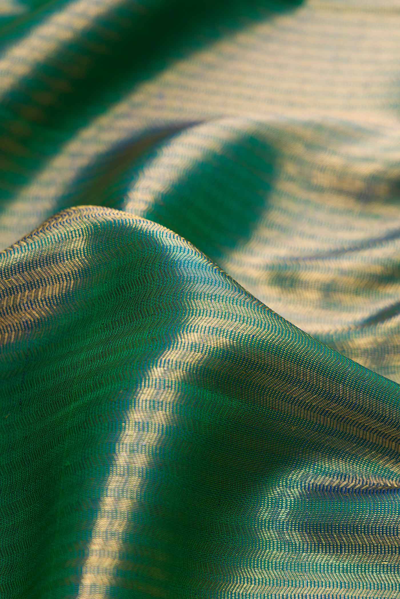 Close up of Peacock Blue Dual Tone Kanchipuram Silk Saree with Zari Brocade on the body and Zari Border.  displaying folds