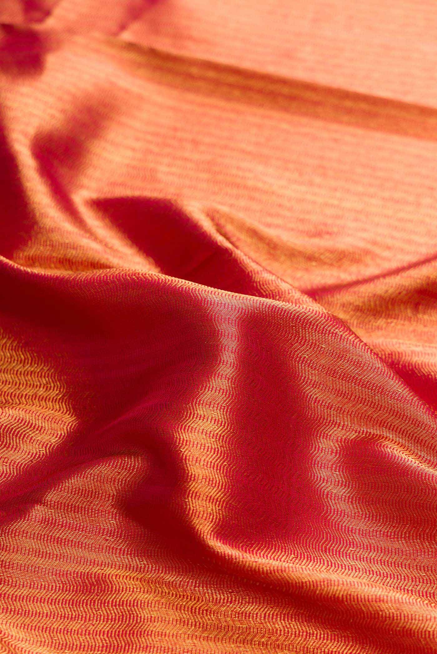 Close up of Maroon Dual Tone Kanchipuram Silk Saree with Zari Brocade on the body and Zari Border displaying folds