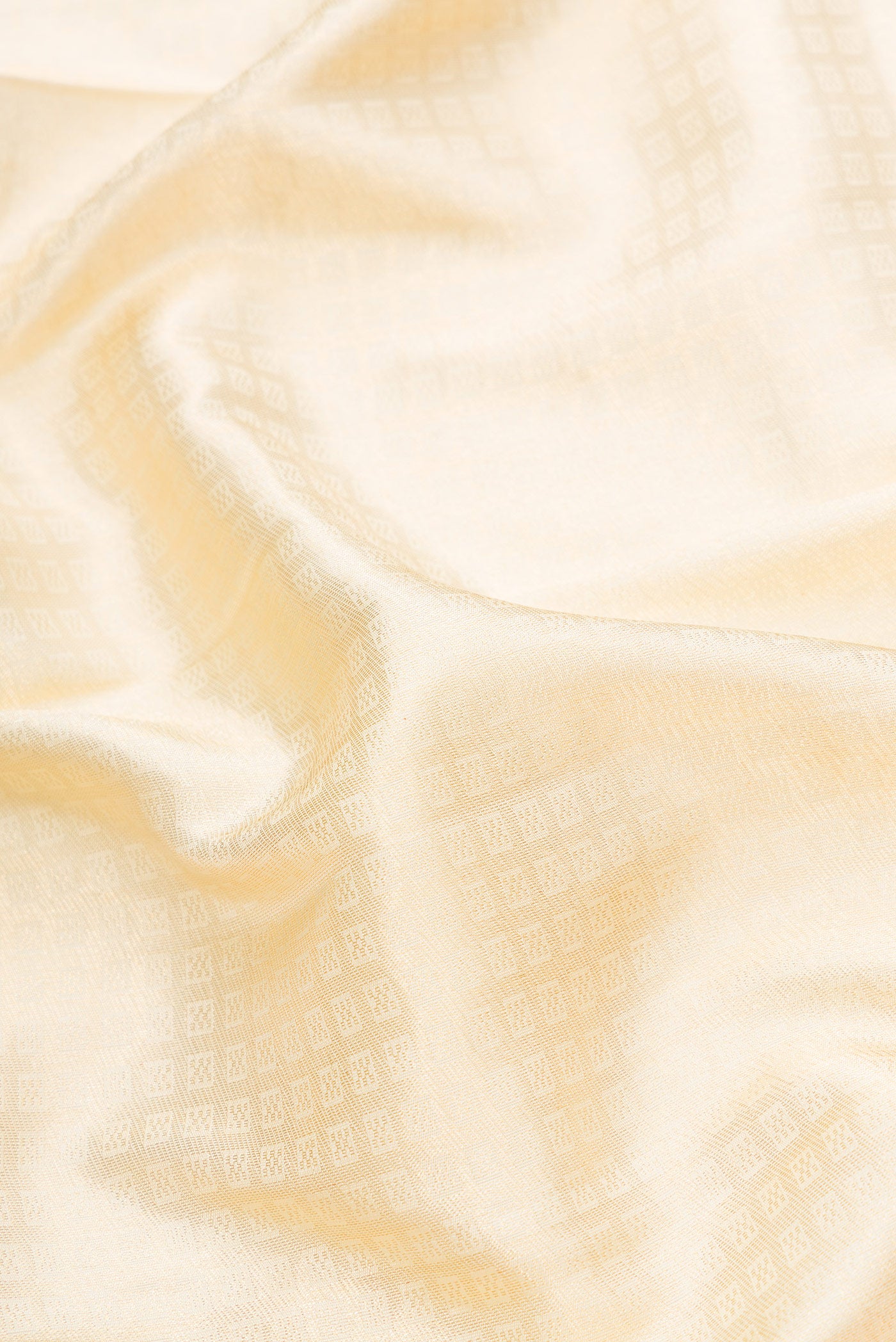 Close up of Off White Dual Tone Kanchipuram Silk Saree with Zari Brocade on the body and Zari Border.  displaying folds
