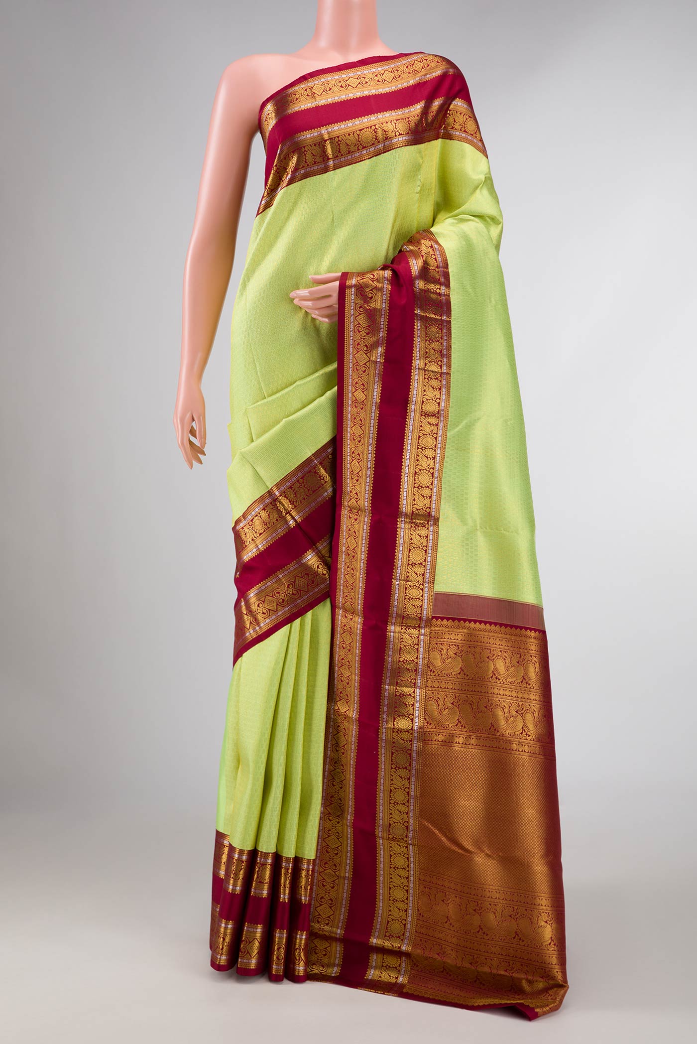 Green Kanchipuram Silk Saree with Zari Brocade on the body and Zari Border displayed on a mannequin