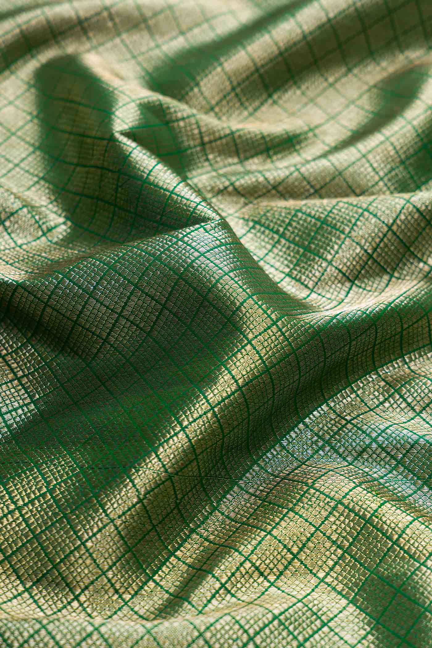 Close up of Green Dual Tone Kanchipuram Silk Saree with Zari Brocade on the body and Zari Border displaying folds