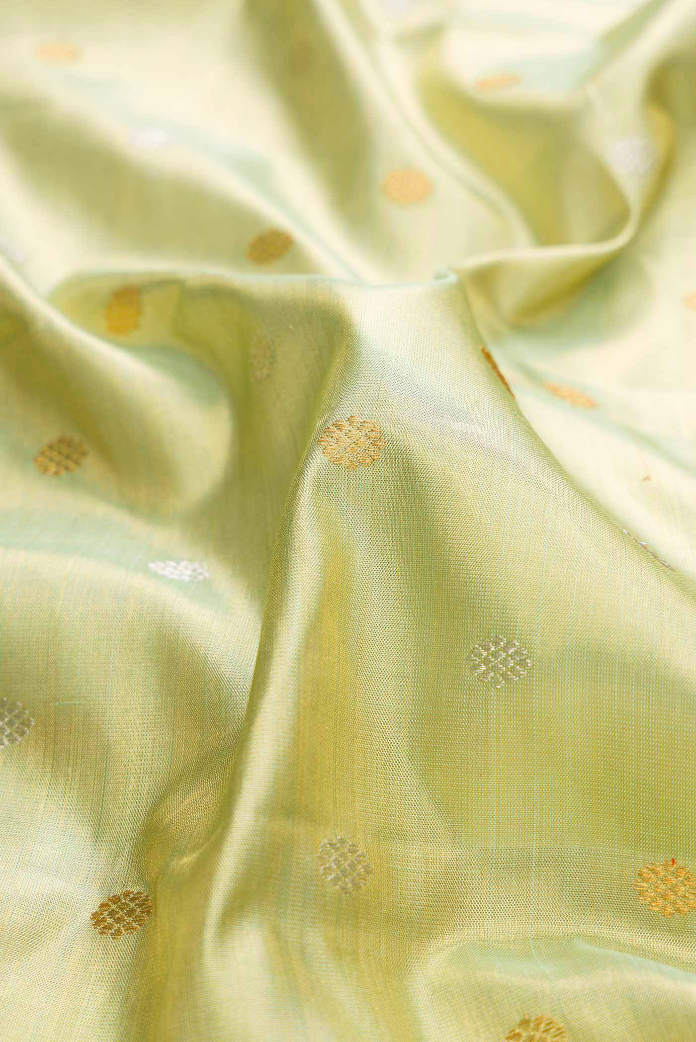 Close up of Pista Green Dual Tone Kanchipuram Silk Saree with Zari Butta on the body and Zari Border displaying folds