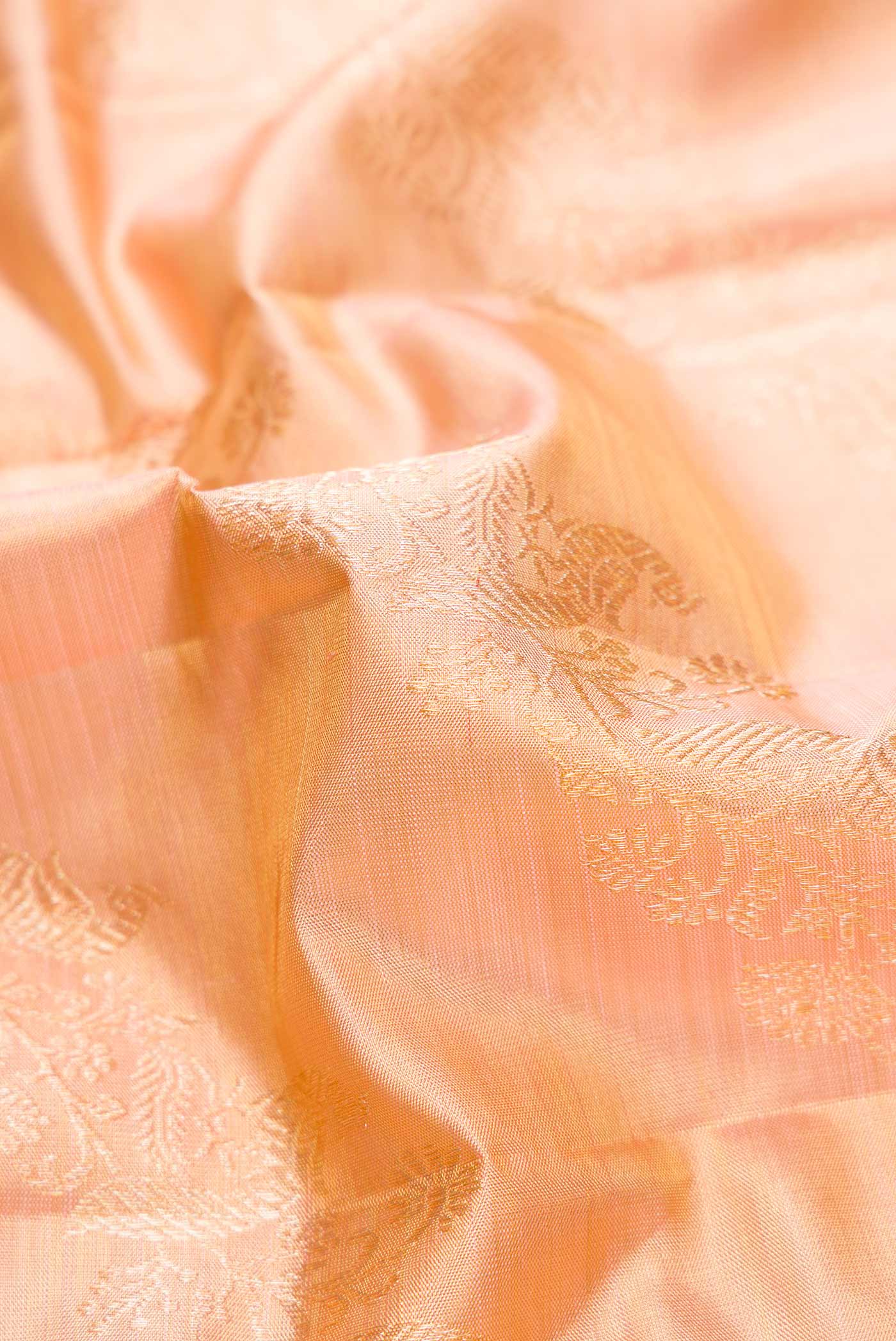Close up of Rose Gold Dual Tone Kanjivaram Tissue Silk Saree with Zari Brocade on the body and Zari Border.  displaying folds