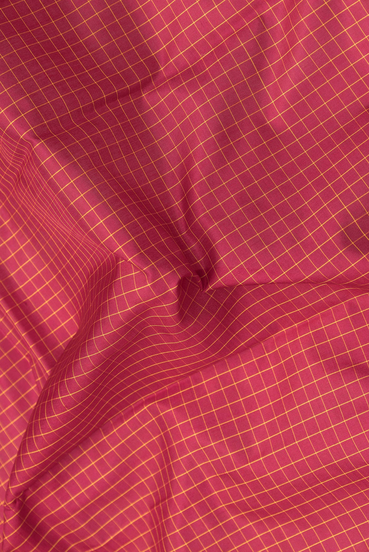 Close up of Maroon Kanchipuram Silk Saree with Checked design on the body and Zari Border.  displaying folds