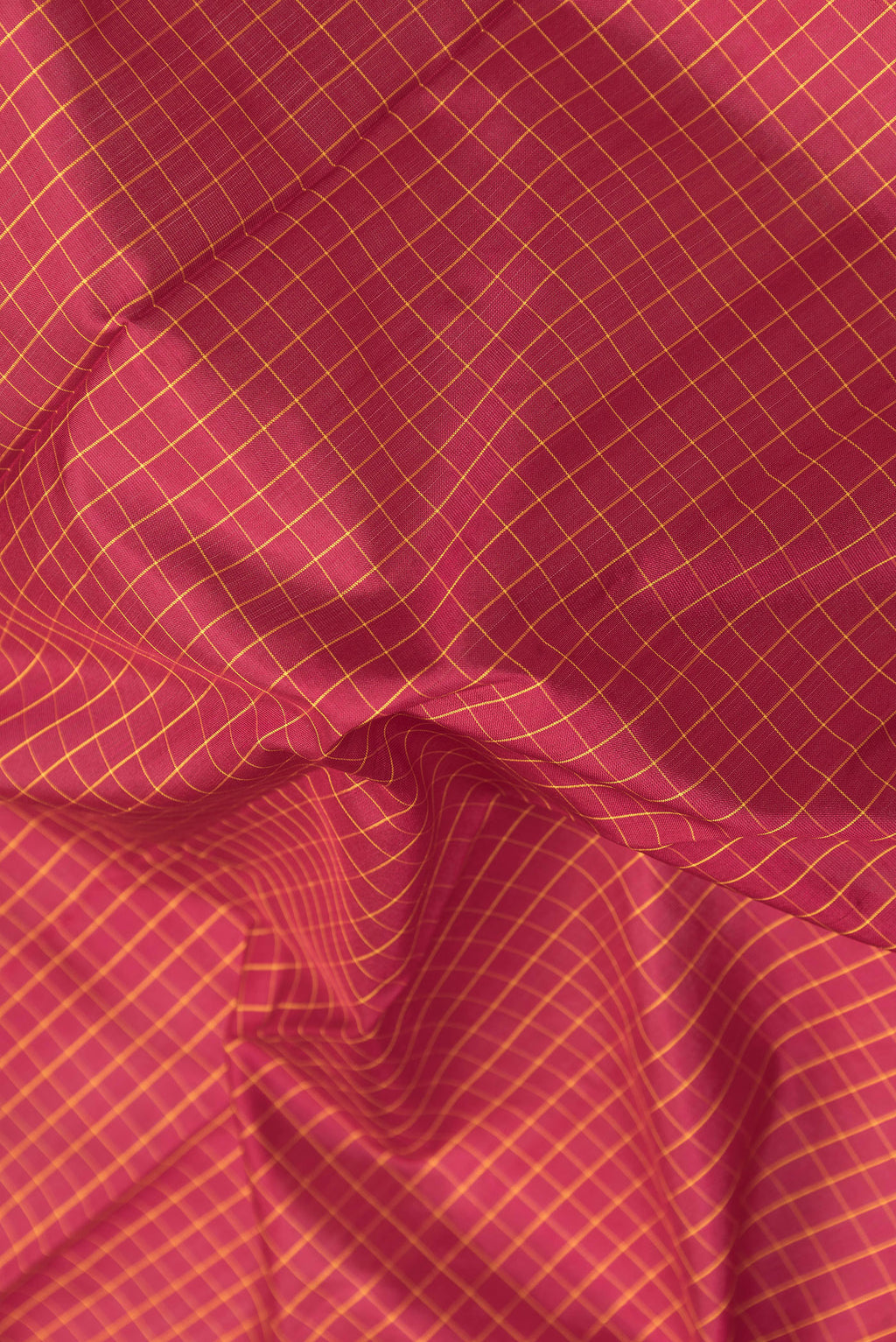 Close up of Maroon Kanchipuram Silk Saree with Checked design on the body and Zari Border.  displaying folds