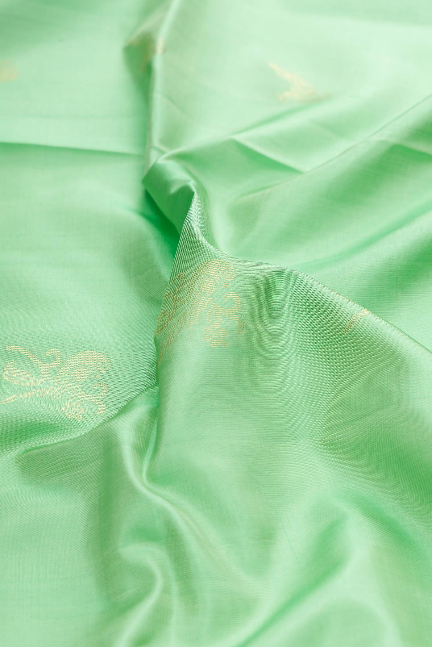 Close up of Pista Green Dual Tone Soft Silk Saree with Zari Butta on the body and Zari Border displaying folds