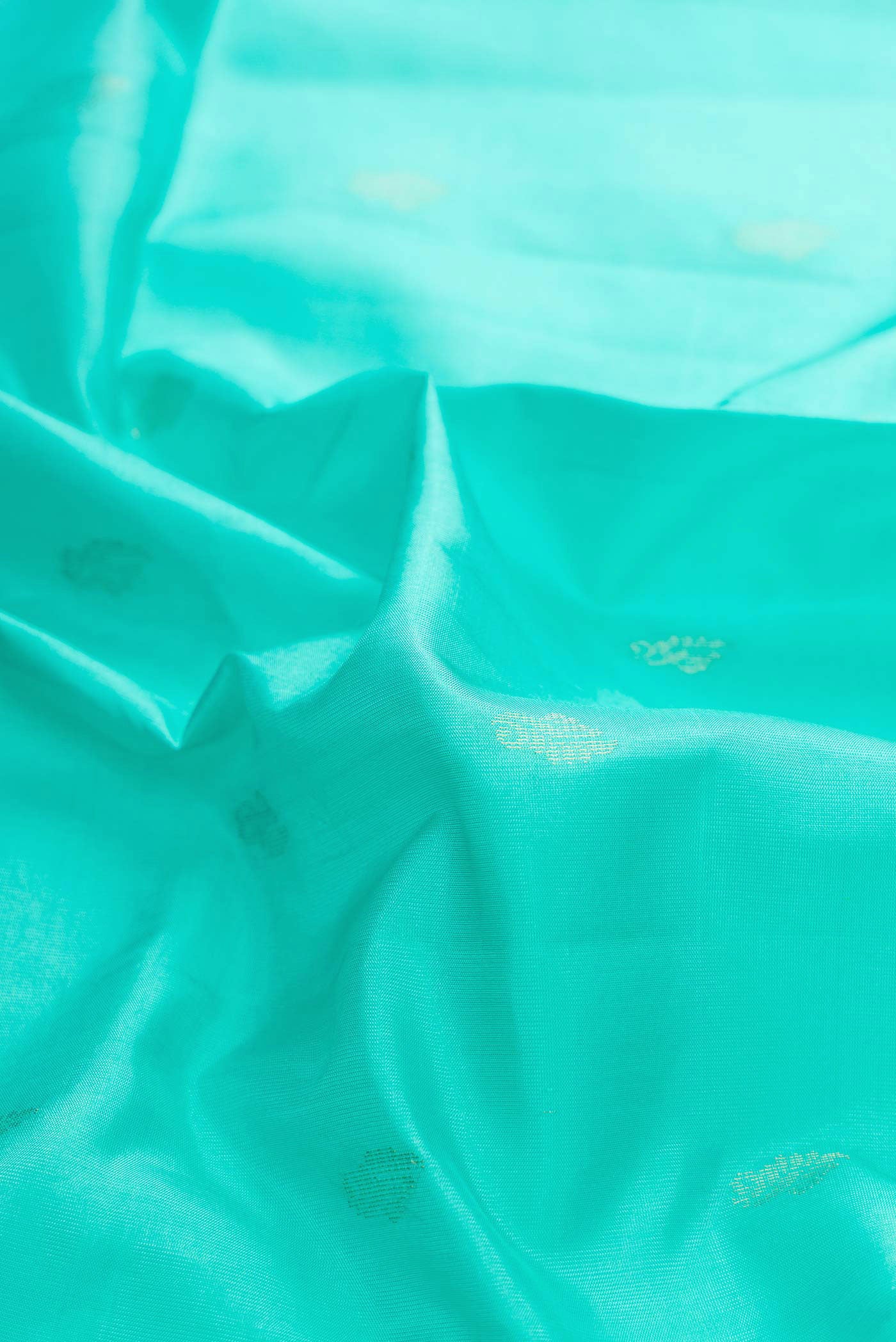 Close up of Sea Green Dual Tone Soft Silk Saree with Zari Butta on the body and Zari Border displaying folds