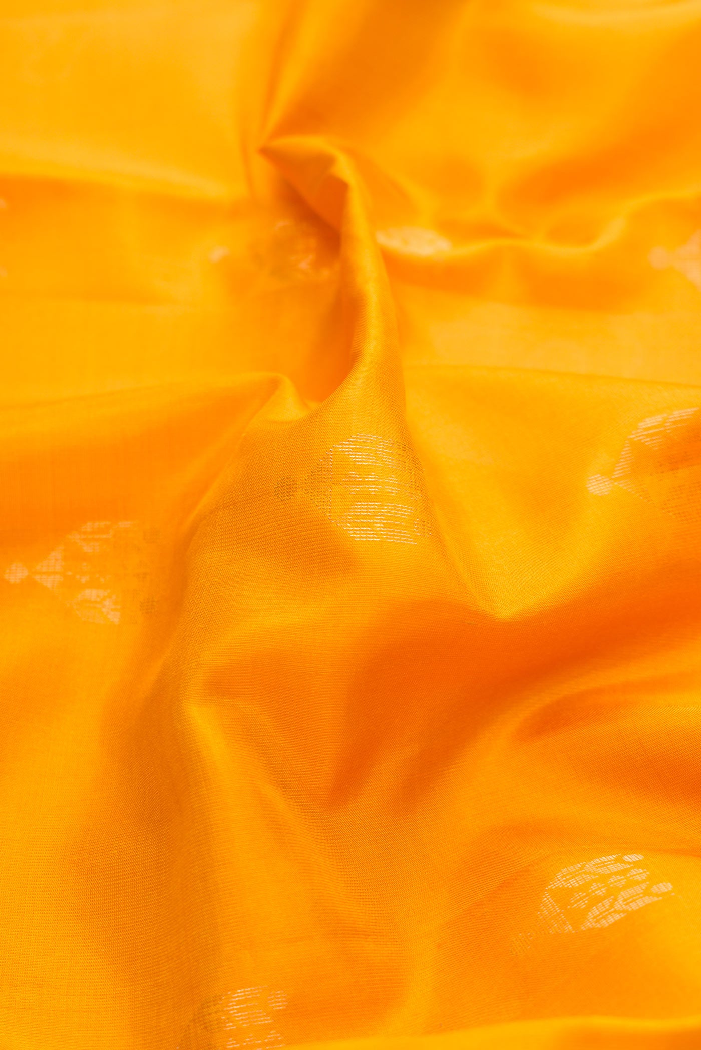 Close up of Mustard Dual Tone Soft Silk Saree with Zari Butta on the body and Zari Border displaying folds
