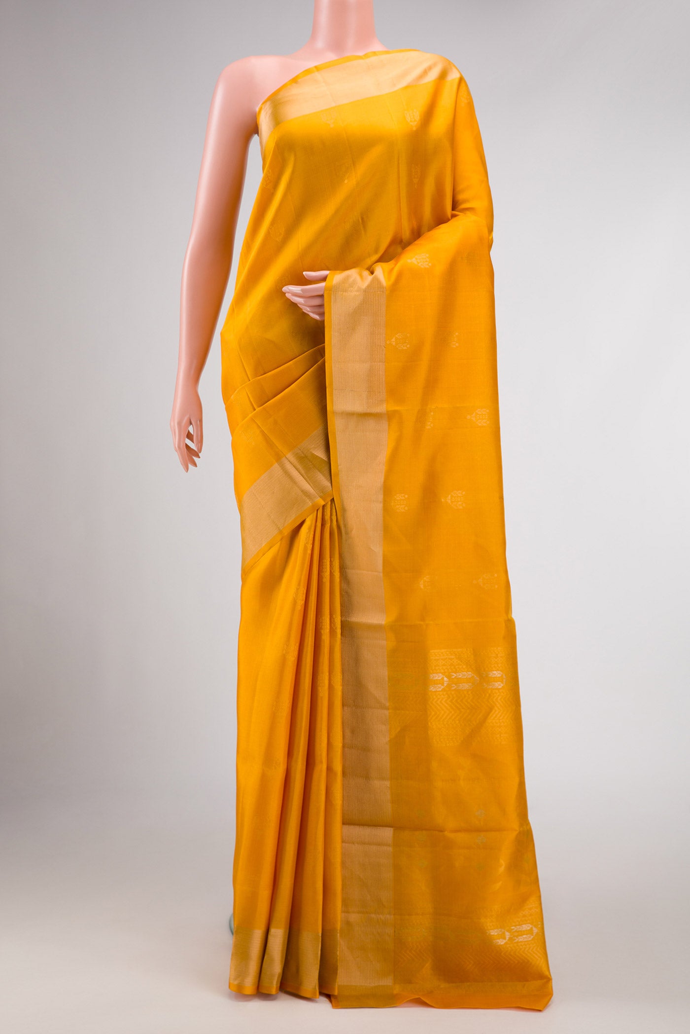 Mustard Dual Tone Soft Silk Saree with Zari Butta on the body and Zari Border displayed on a mannequin