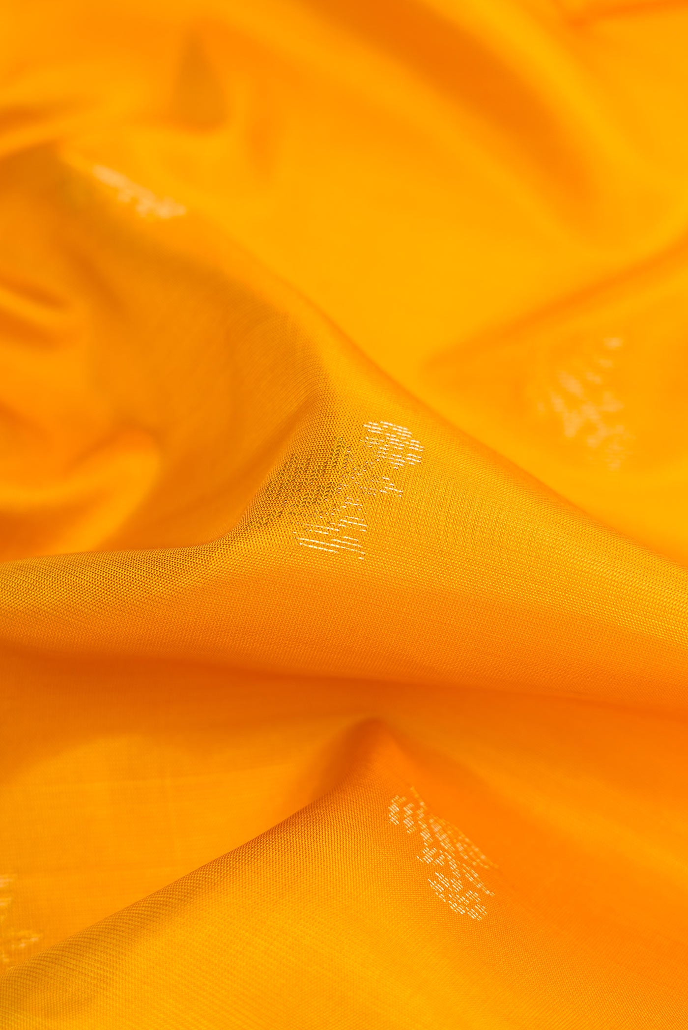 Close up of Mustard Dual Tone Soft Silk Saree with Zari Butta on the body and Zari Border displaying folds