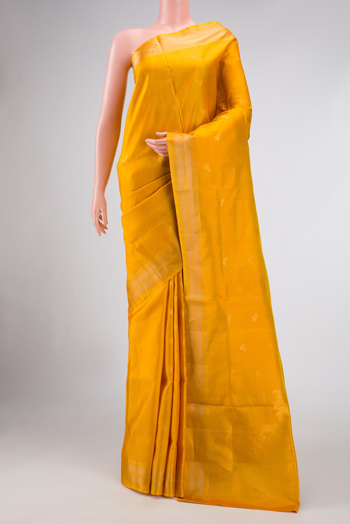 Mustard Dual Tone Soft Silk Saree with Zari Butta on the body and Zari Border displayed on a mannequin