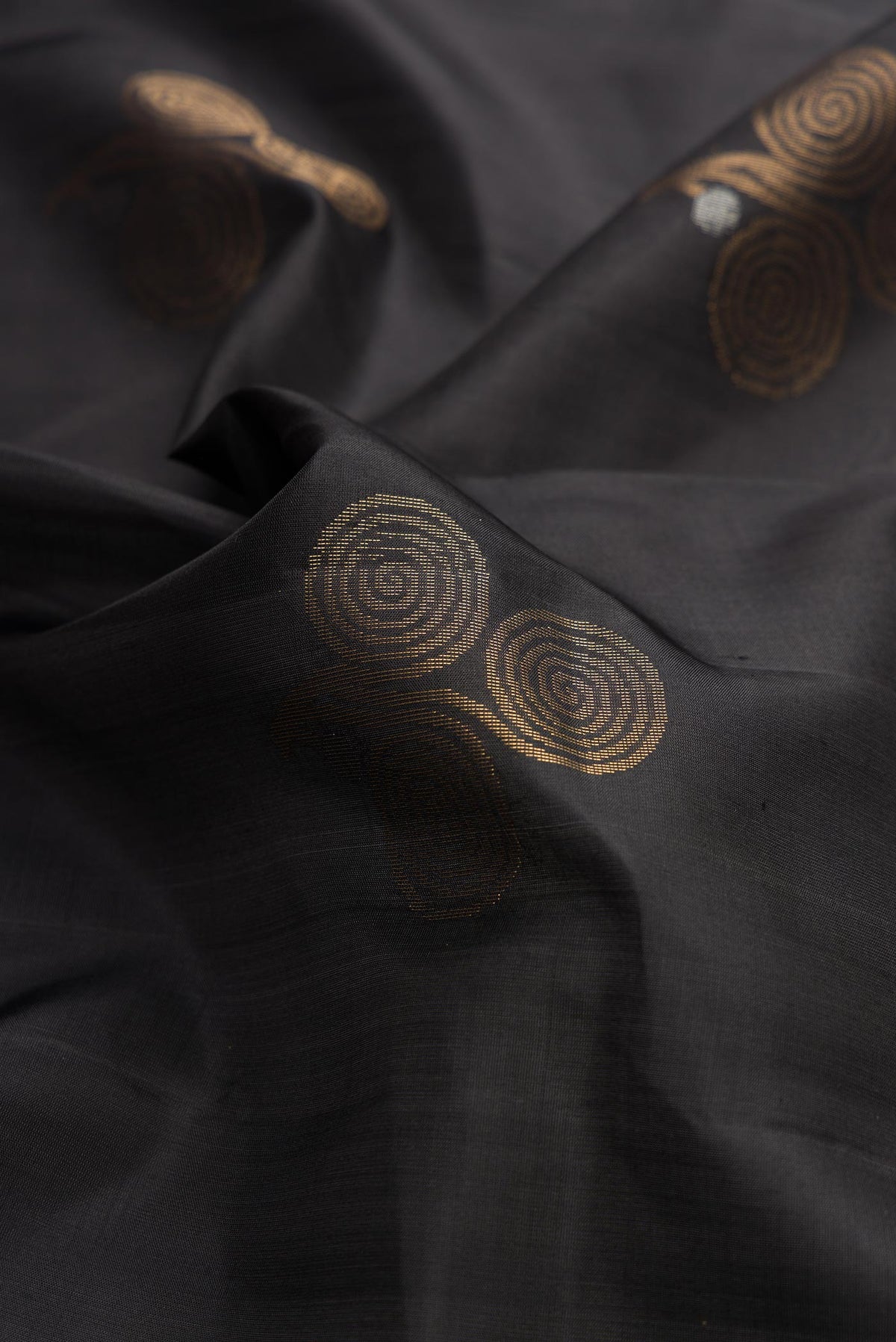 Close up of Black Dual Tone Soft Silk Saree with Zari Butta on the body and Zari Border displaying folds