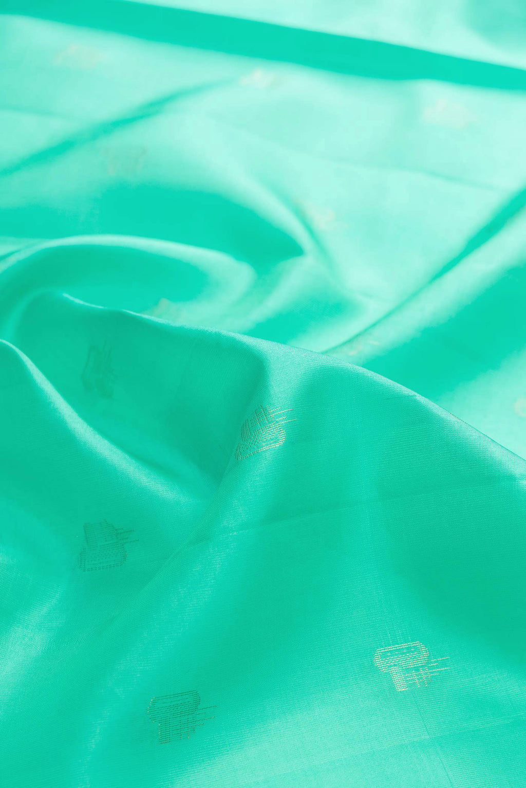 Close up of Sea Green Dual Tone Soft Silk Saree with Zari Butta on the body and Zari Border displaying folds