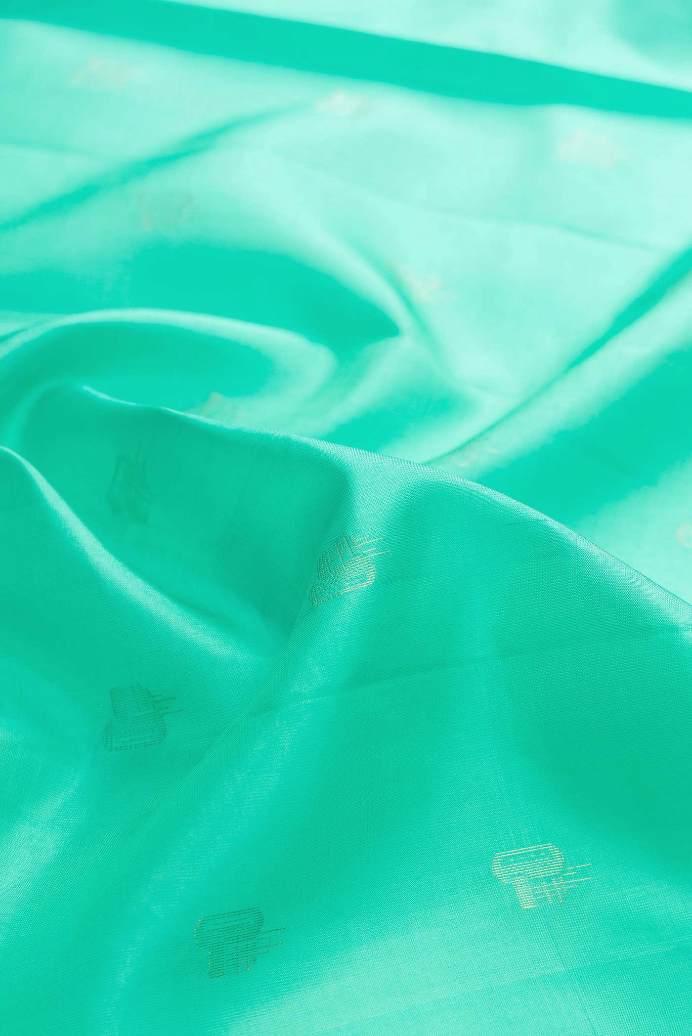 Close up of Sea Green Dual Tone Soft Silk Saree with Zari Butta on the body and Zari Border displaying folds