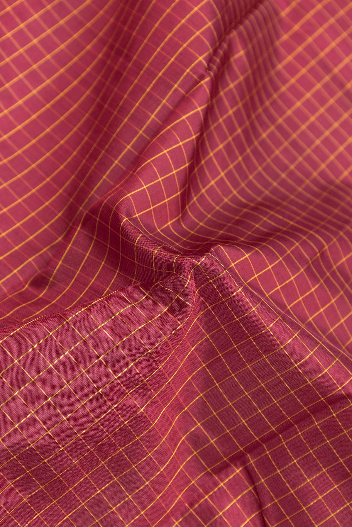 Close up of Maroon Kanjivaram Silk Saree with Checked design on the body and Zari Border.  displaying folds