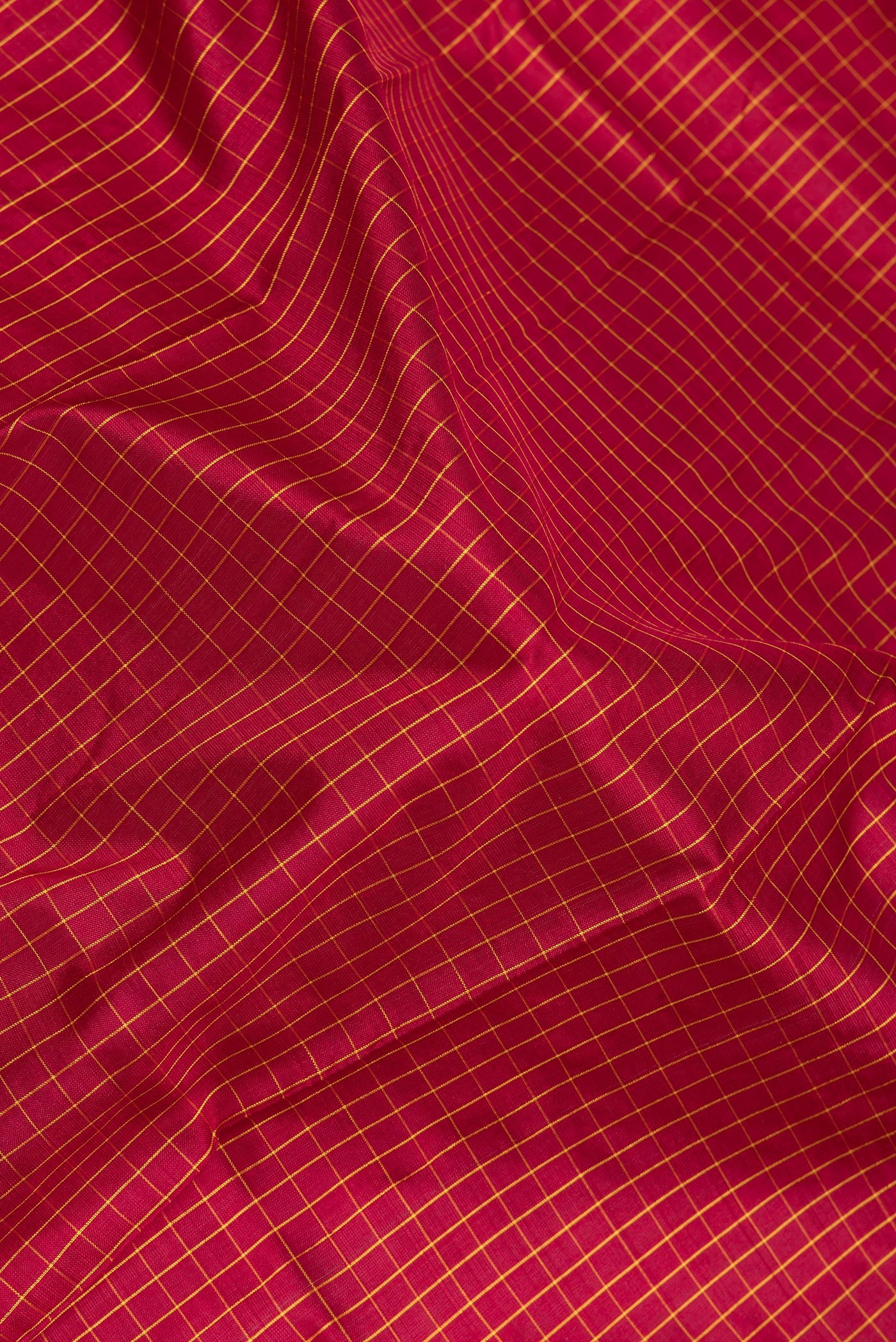Close up of Maroon Kanjivaram Silk Saree with Checked design on the body and Zari Border.  displaying folds