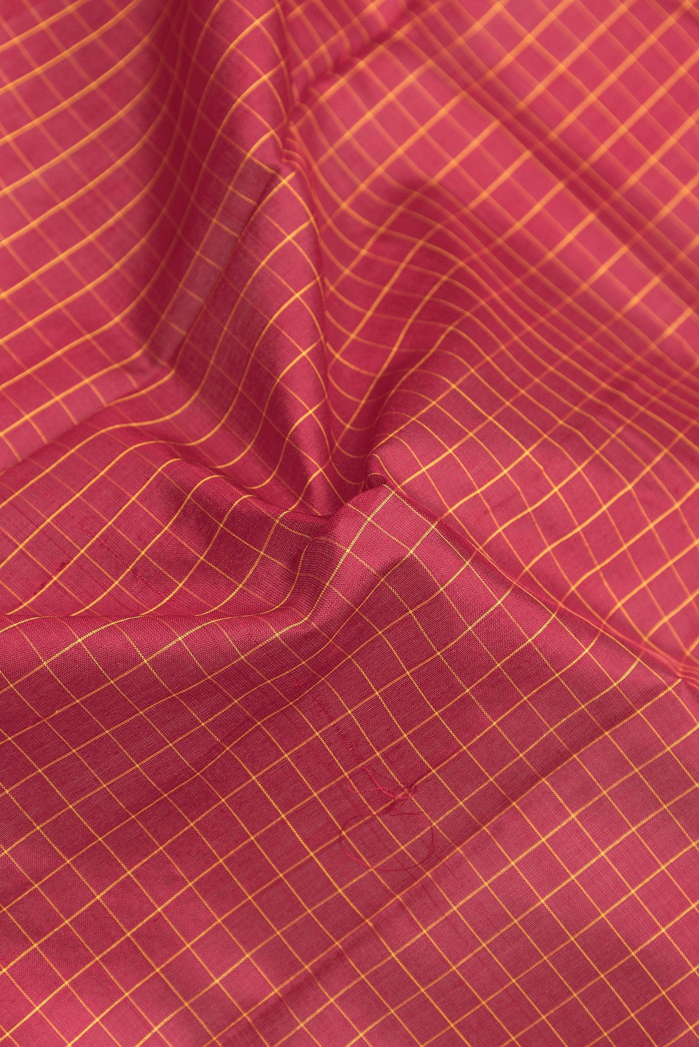 Close up of Maroon Kanjivaram Silk Saree with Checked design on the body and Zari Border.  displaying folds
