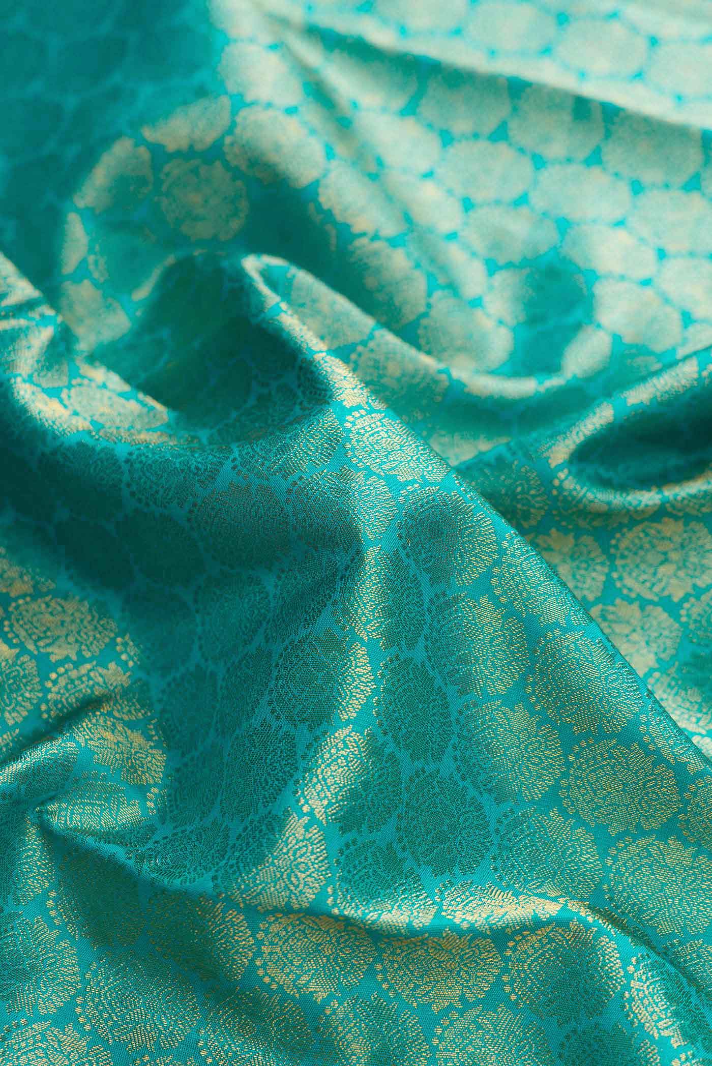 Close up of Peacock Blue Dual Tone Kanchipuram Silk Saree with Zari Brocade on the body and Zari Border displaying folds