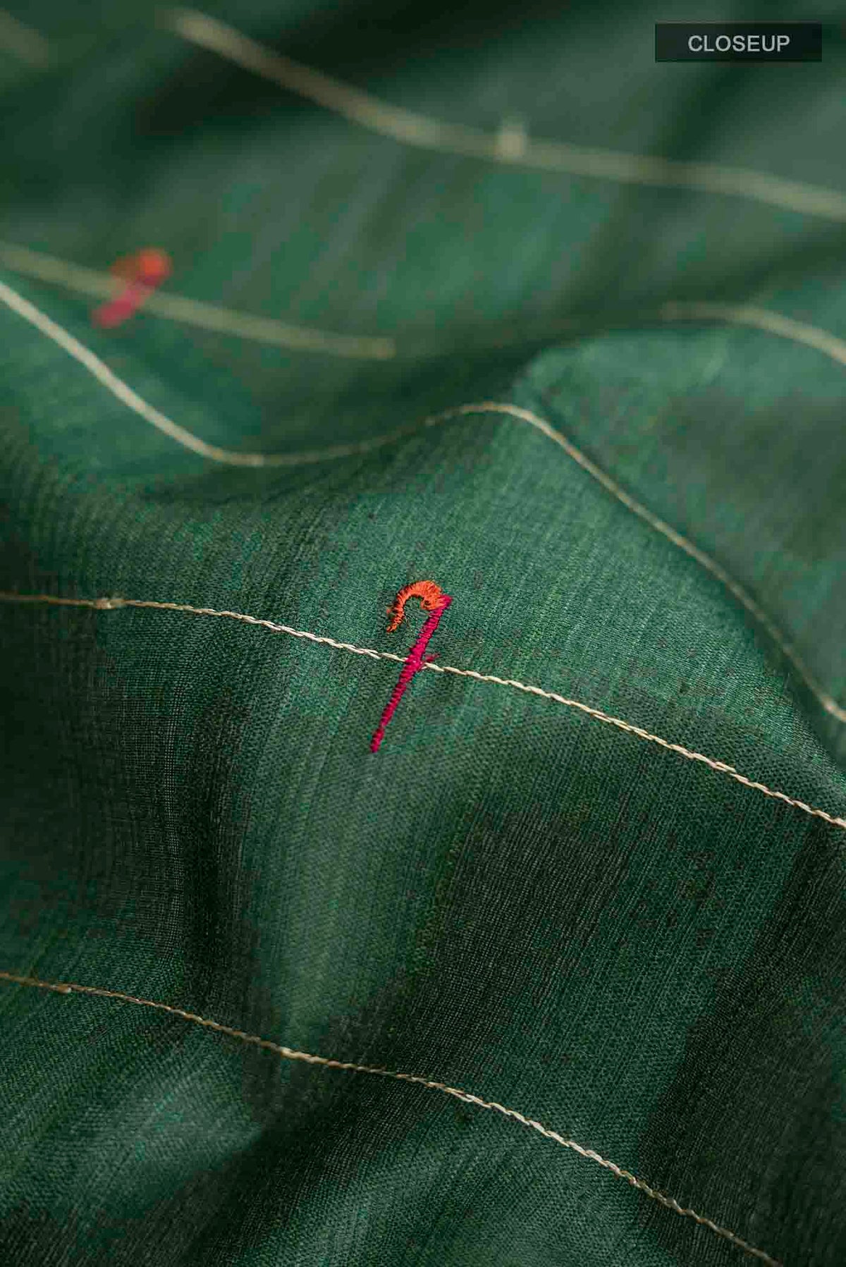 Close up of Green Tussar Silk Saree with Stripes on the body and Zari Border displaying folds