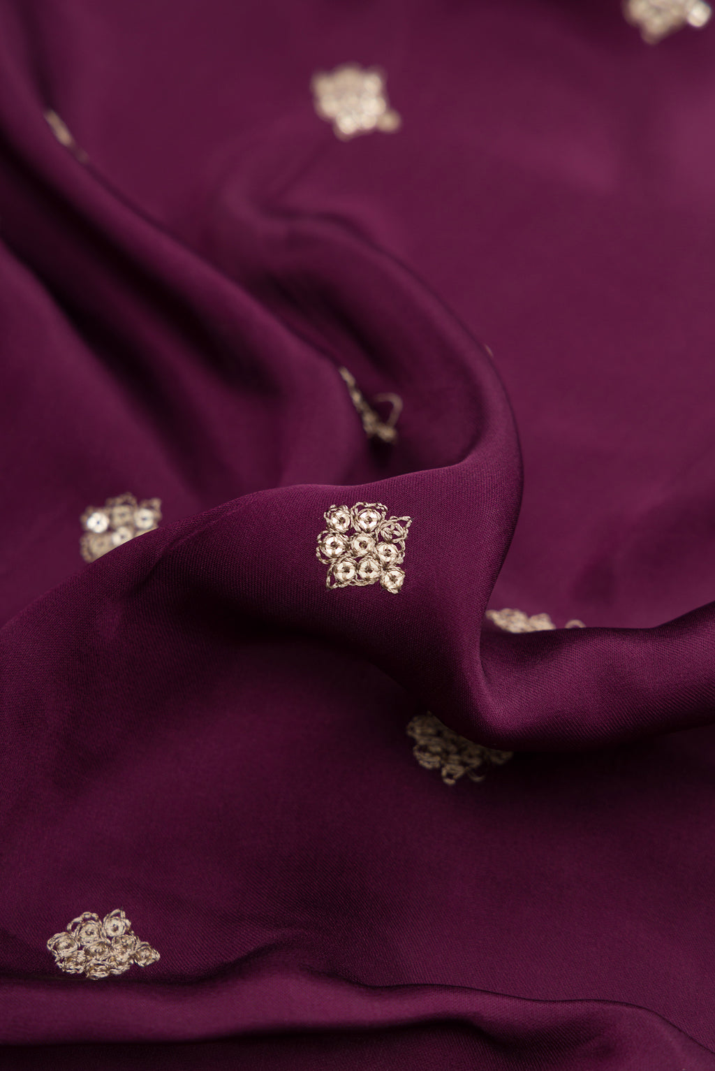 Close up of Burgundy Dual Tone Mysore Crepe Saree with Embroidery on the body and Embroidery Border.  displaying folds
